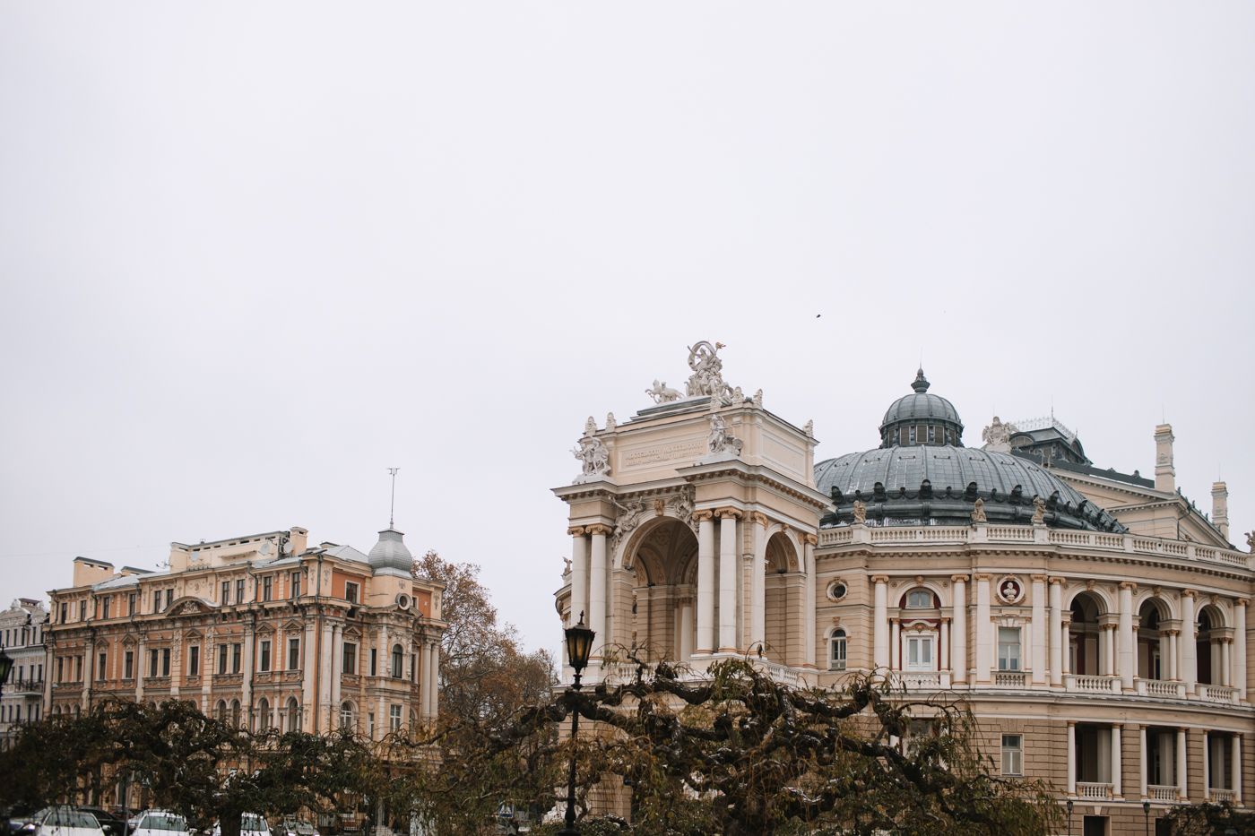 Historic opera house facade with classical architecture in overcast weather.