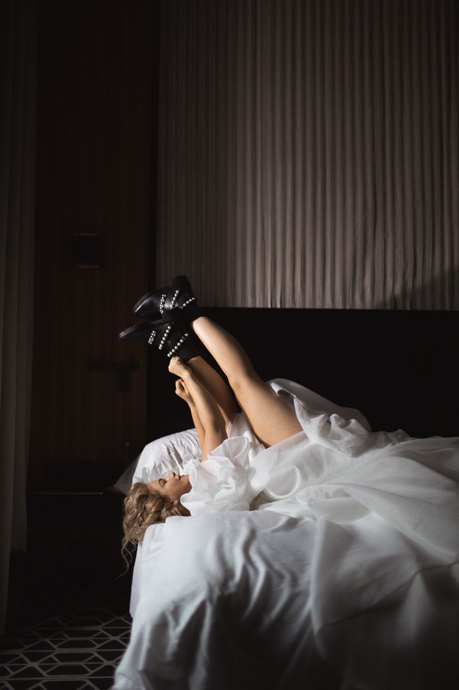 Artistic sequence of person reclining on bed in dark room.