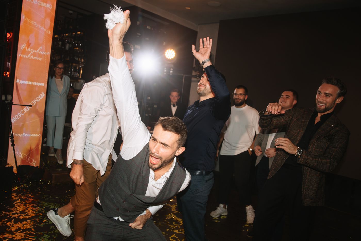 Dance floor moments captured in dark ambient lighting at wedding celebration.