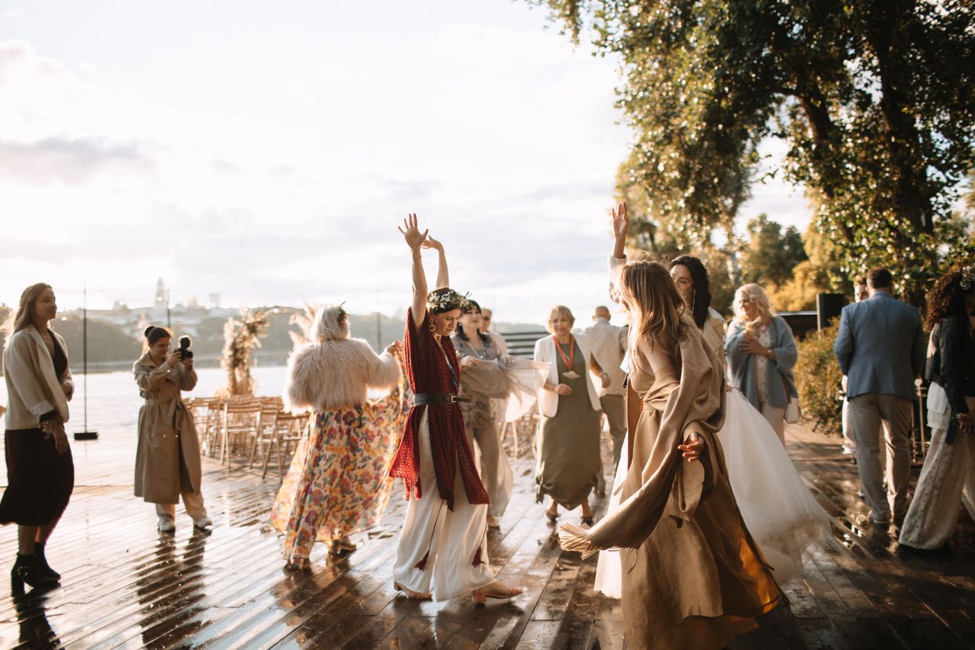 A series of silhouetted figures stand together outdoors during golden hour with sunlight creating a dreamy atmosphere.