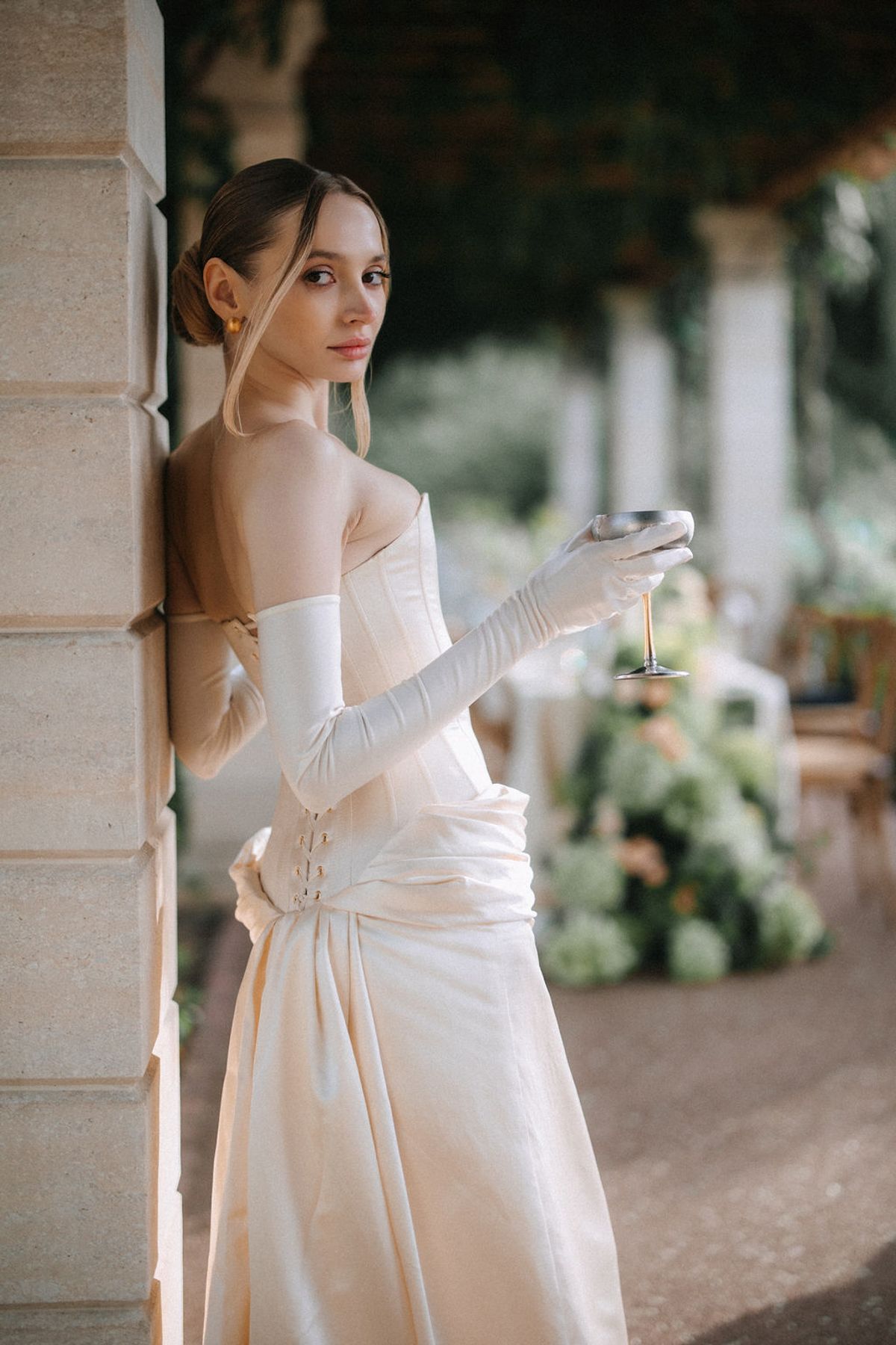 A series of romantic bridal portraits showing a woman in a white wedding dress posing against stone columns outdoors.