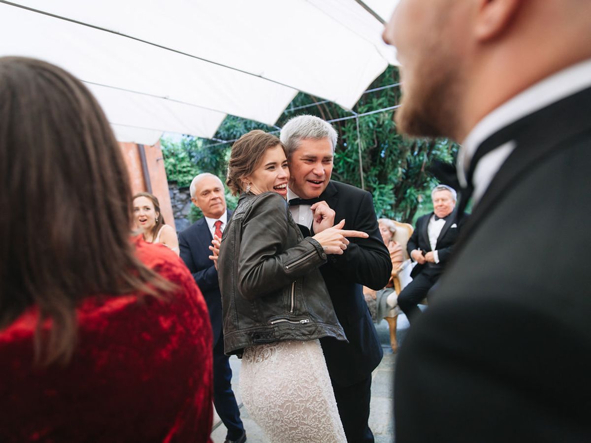 People dancing and socializing at an outdoor event with guests in formal attire.
