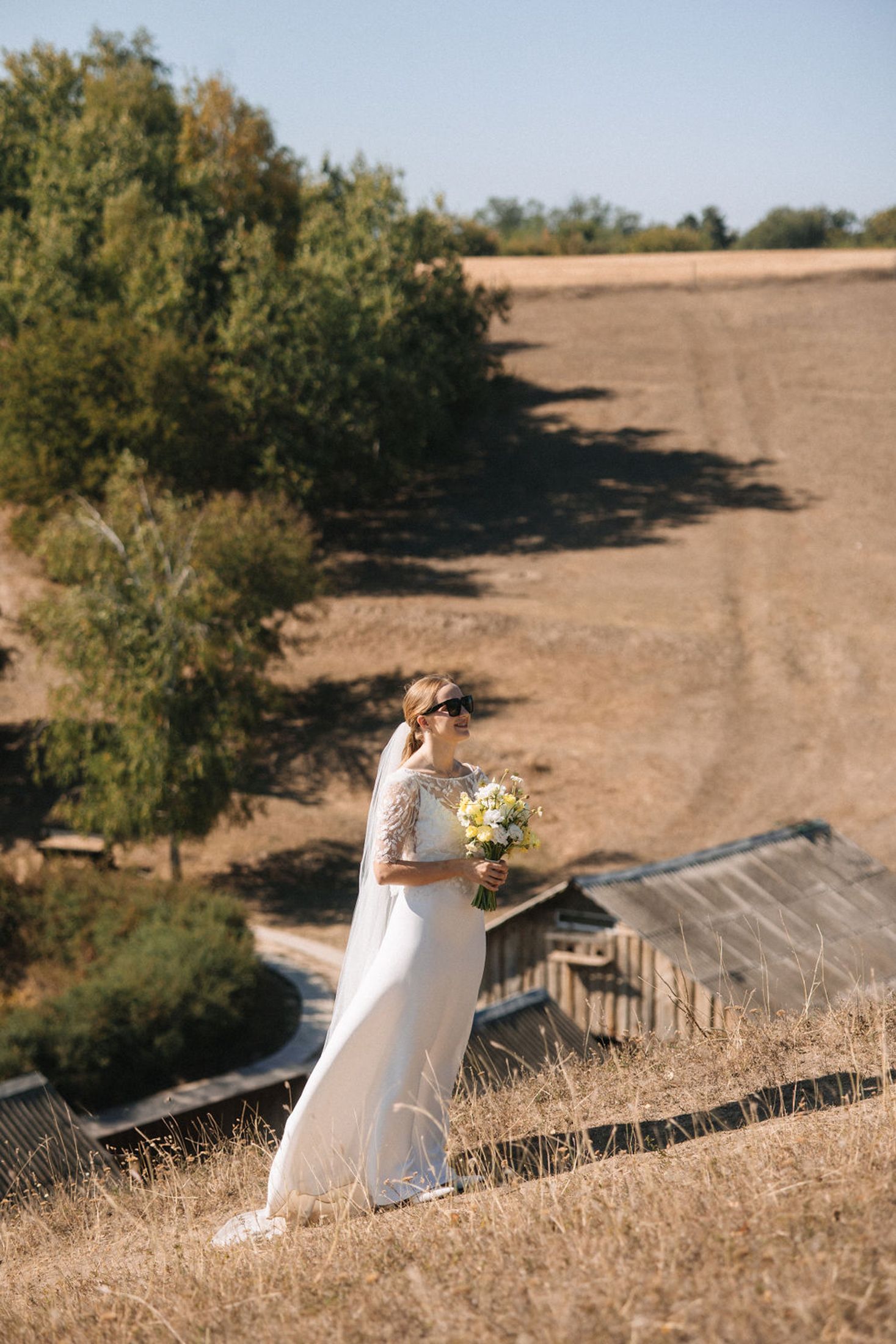 A series of photos showing a bride in a white dress sitting on a golden hillside at sunset.