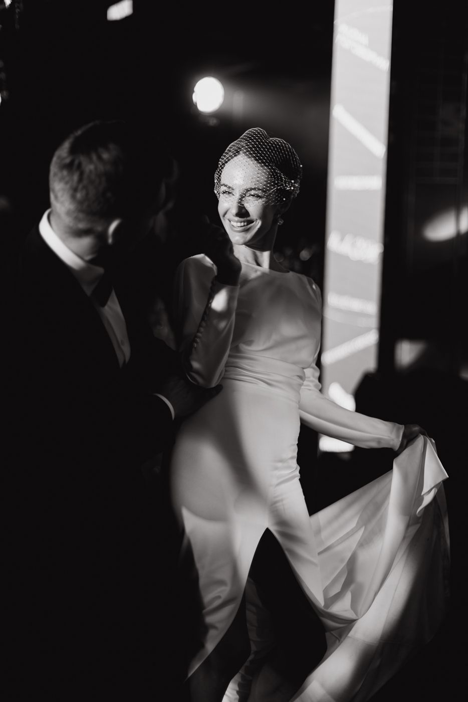 A couple dances together at an elegant black and white wedding reception.