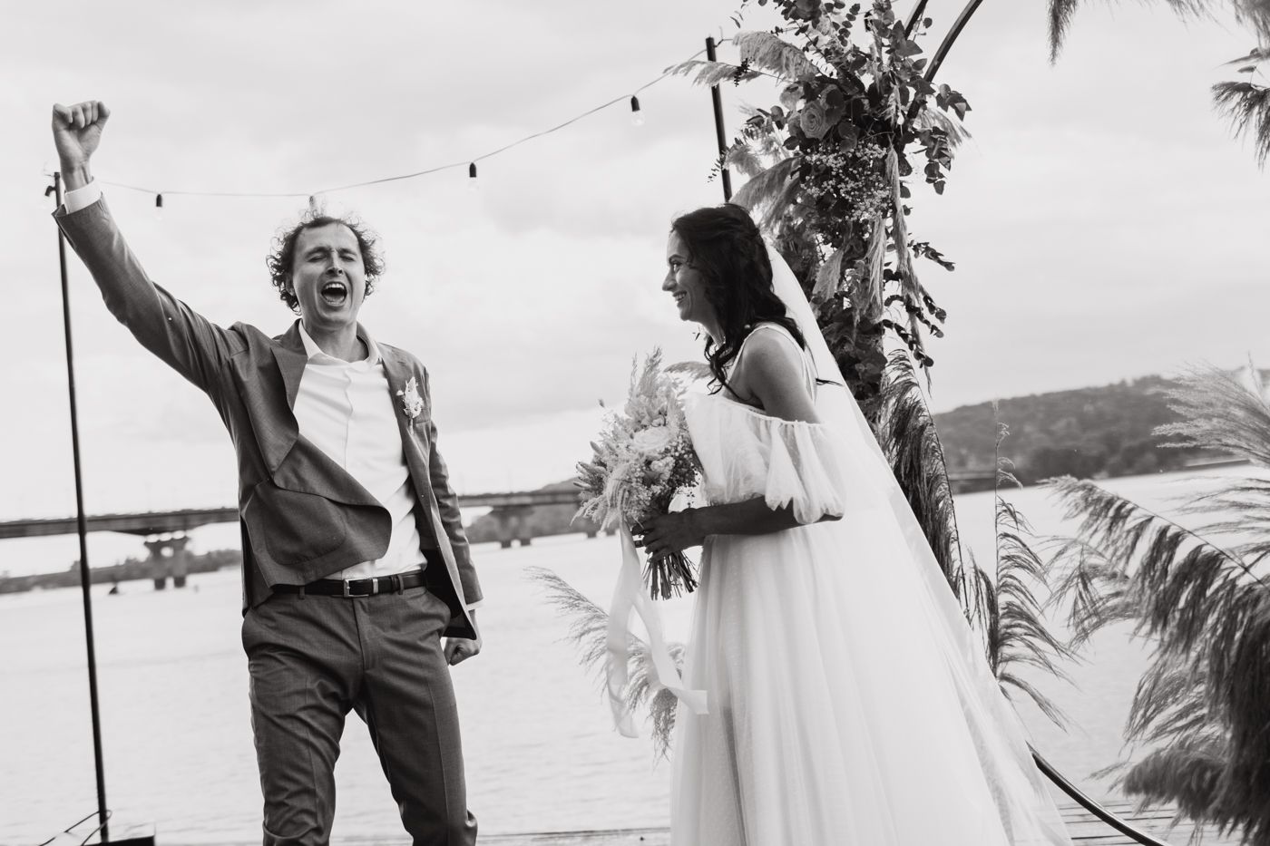 A black and white collage of candid wedding moments showing people dancing and celebrating outdoors by the ocean.