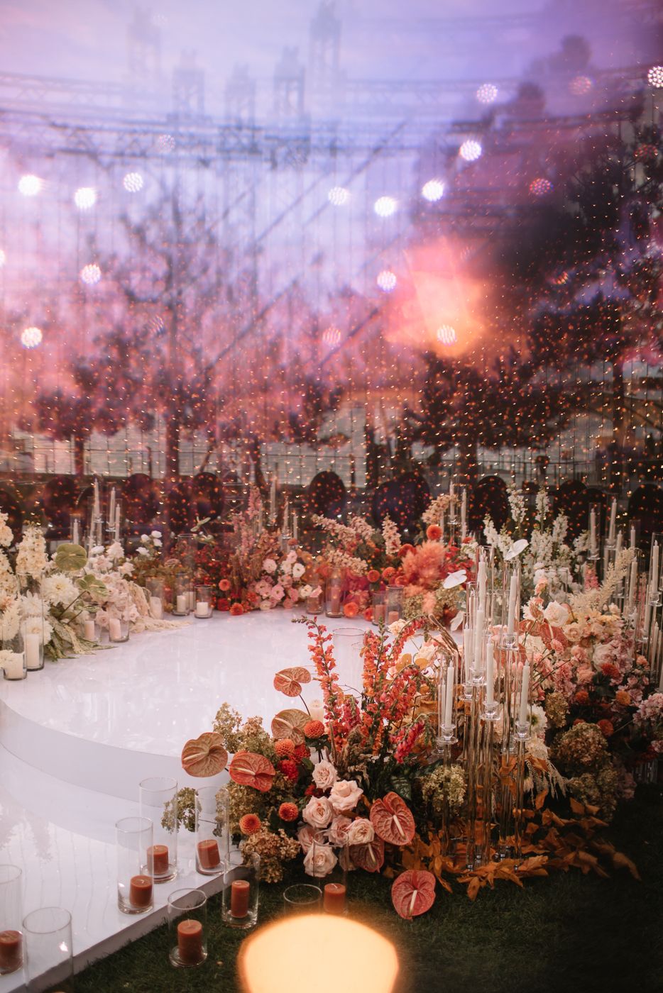 Romantic wedding reception setup with pink floral arrangements and ambient lighting.