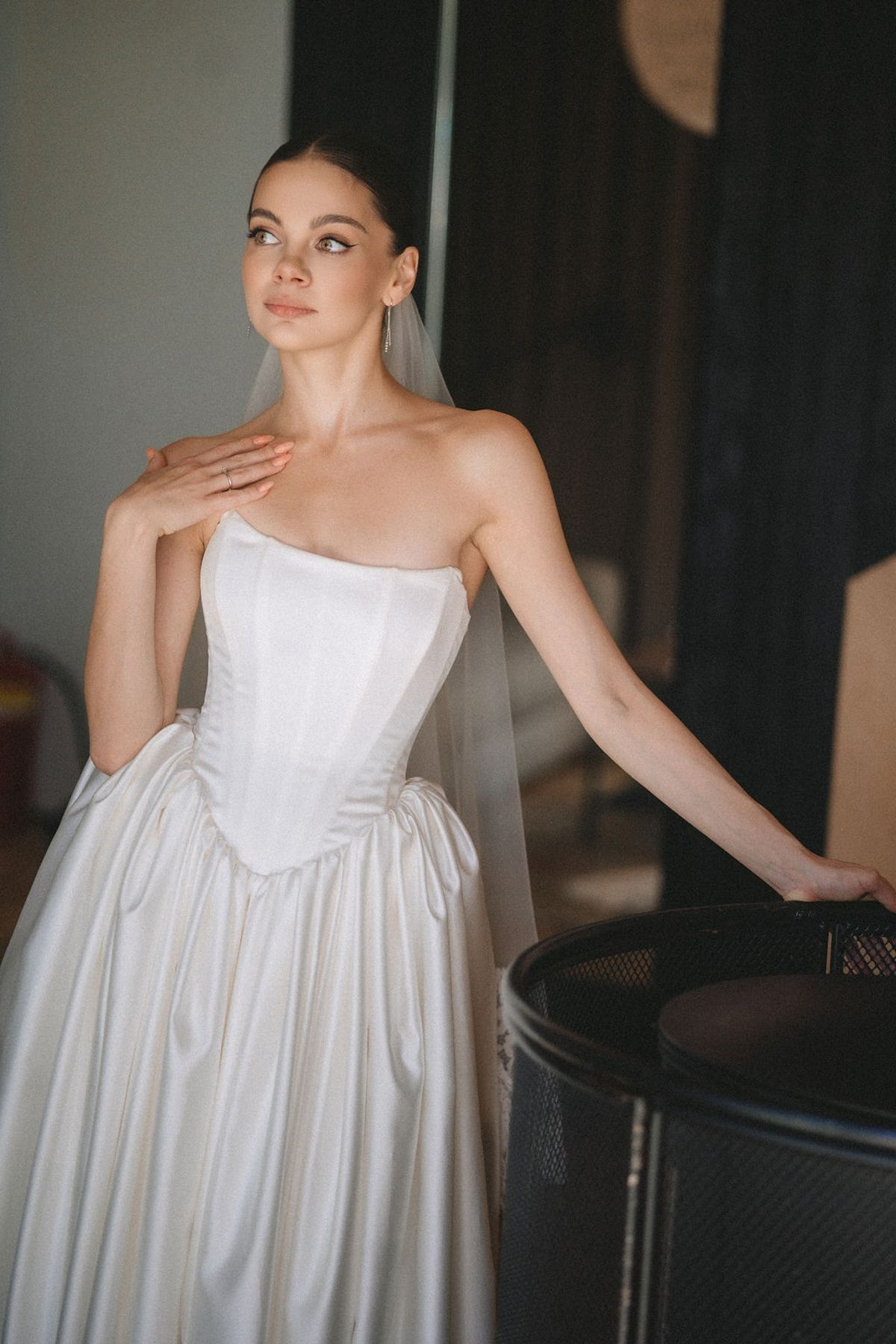 A series of artistic bridal portraits showing a white strapless wedding gown with an empire waist in dramatic lighting.