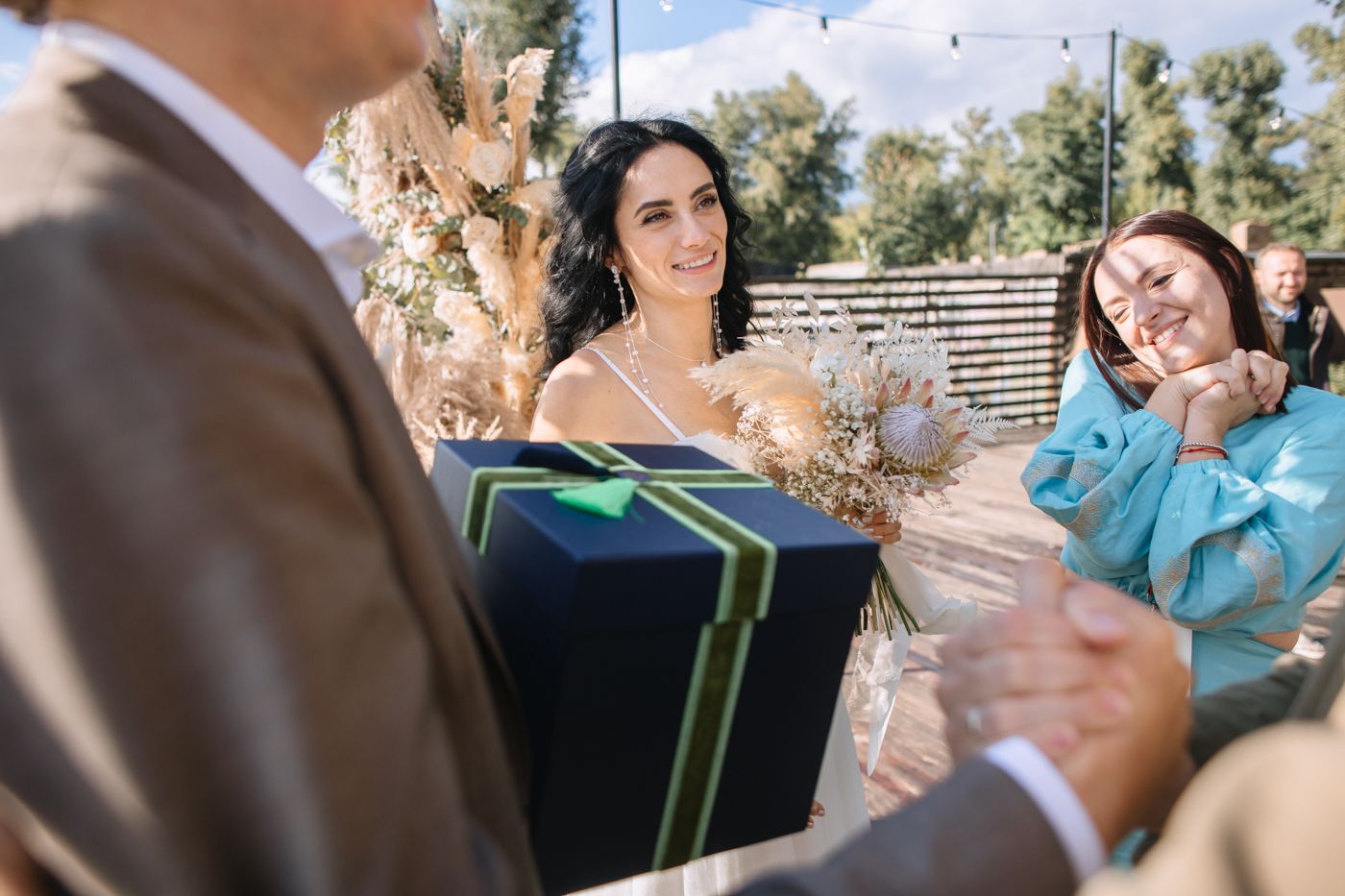 A couple shares a joyful moment together during a sunny outdoor wedding celebration.
