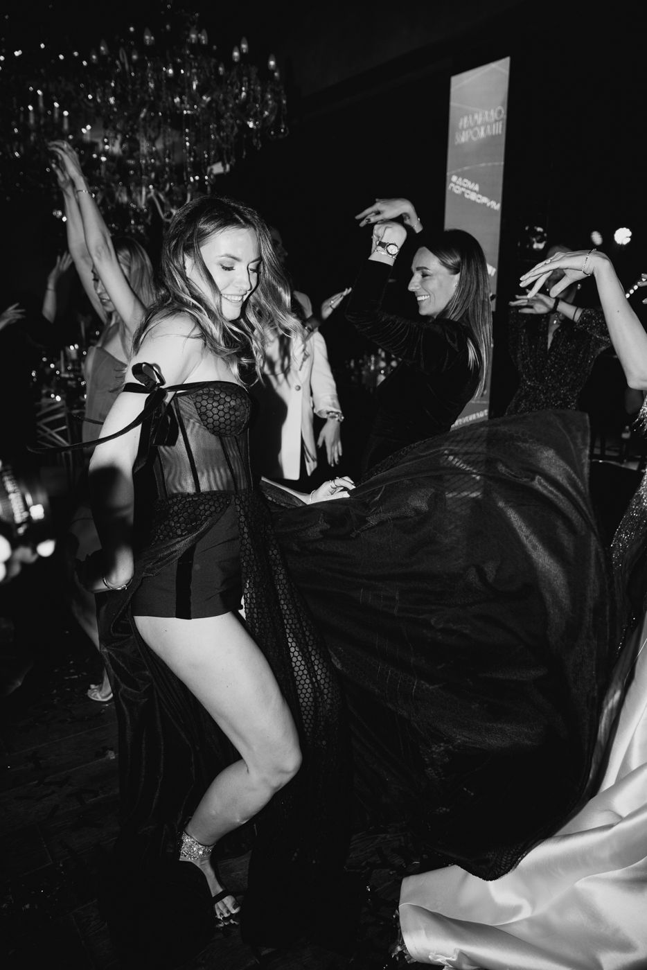 Party guests dancing energetically in formal attire at a celebration.