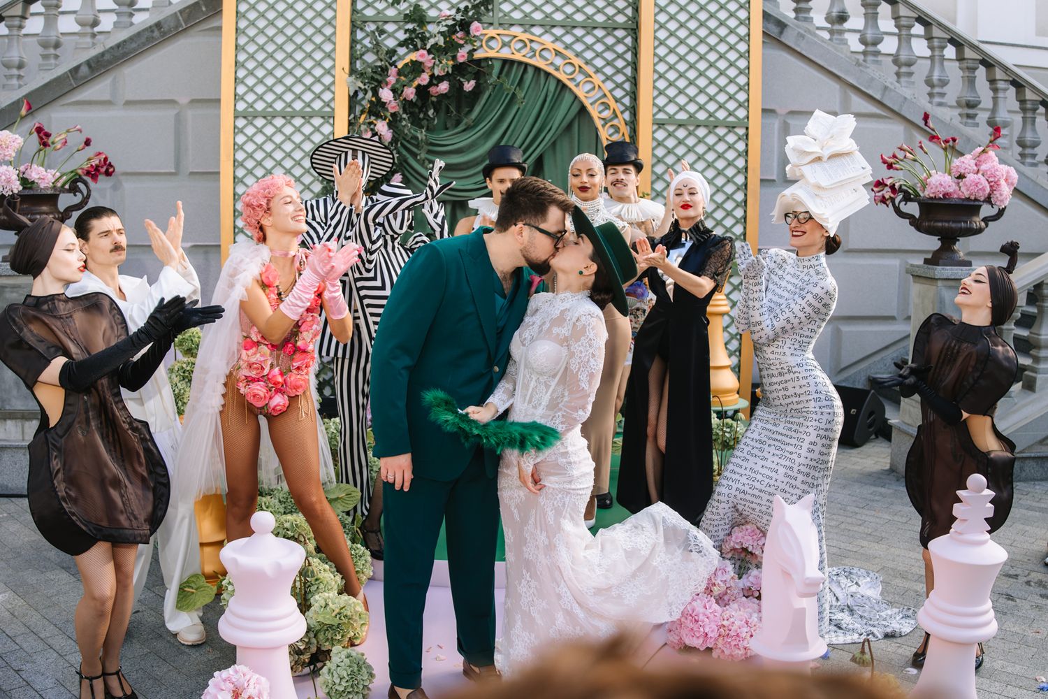 A couple shares a romantic moment at an outdoor celebration surrounded by festive decor and attendees.