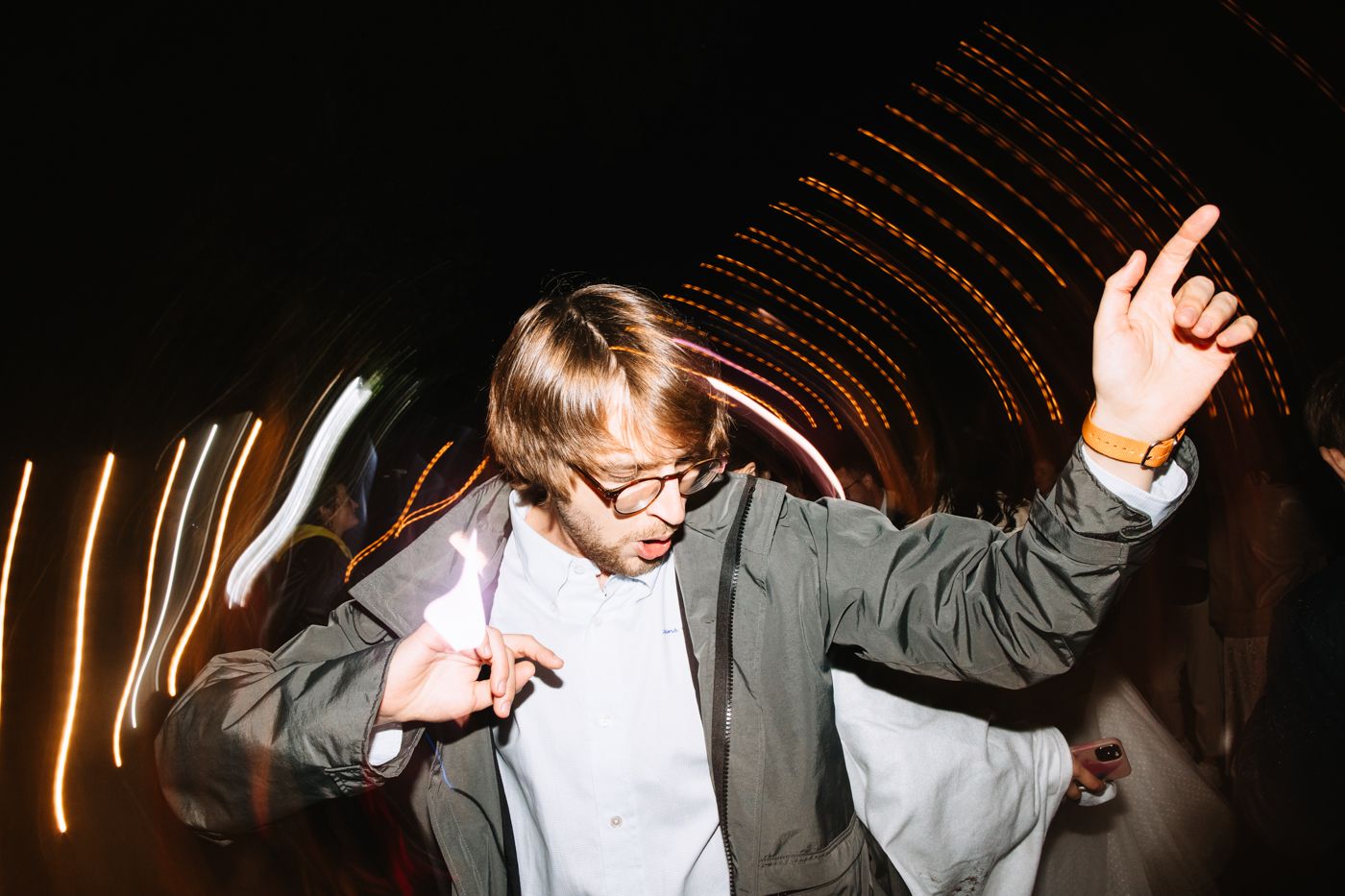 A series of five photos showing a child dancing and moving expressively against a dark background with light trails.