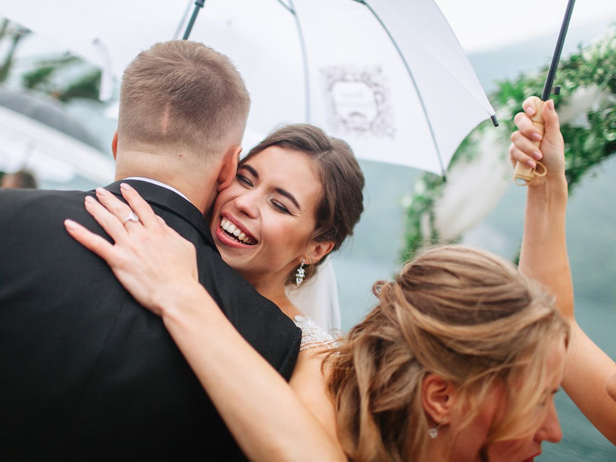 Wedding guests dance joyfully together at a celebration in an elegant indoor venue.