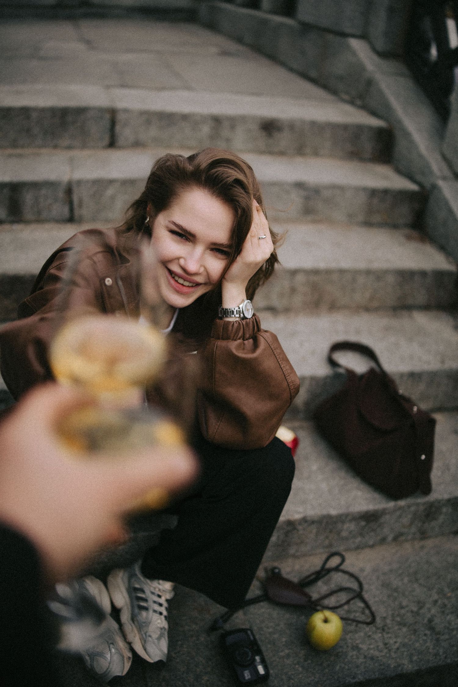 A sequence of moody artistic photographs showing someone sitting on concrete steps with an apple and backpack.