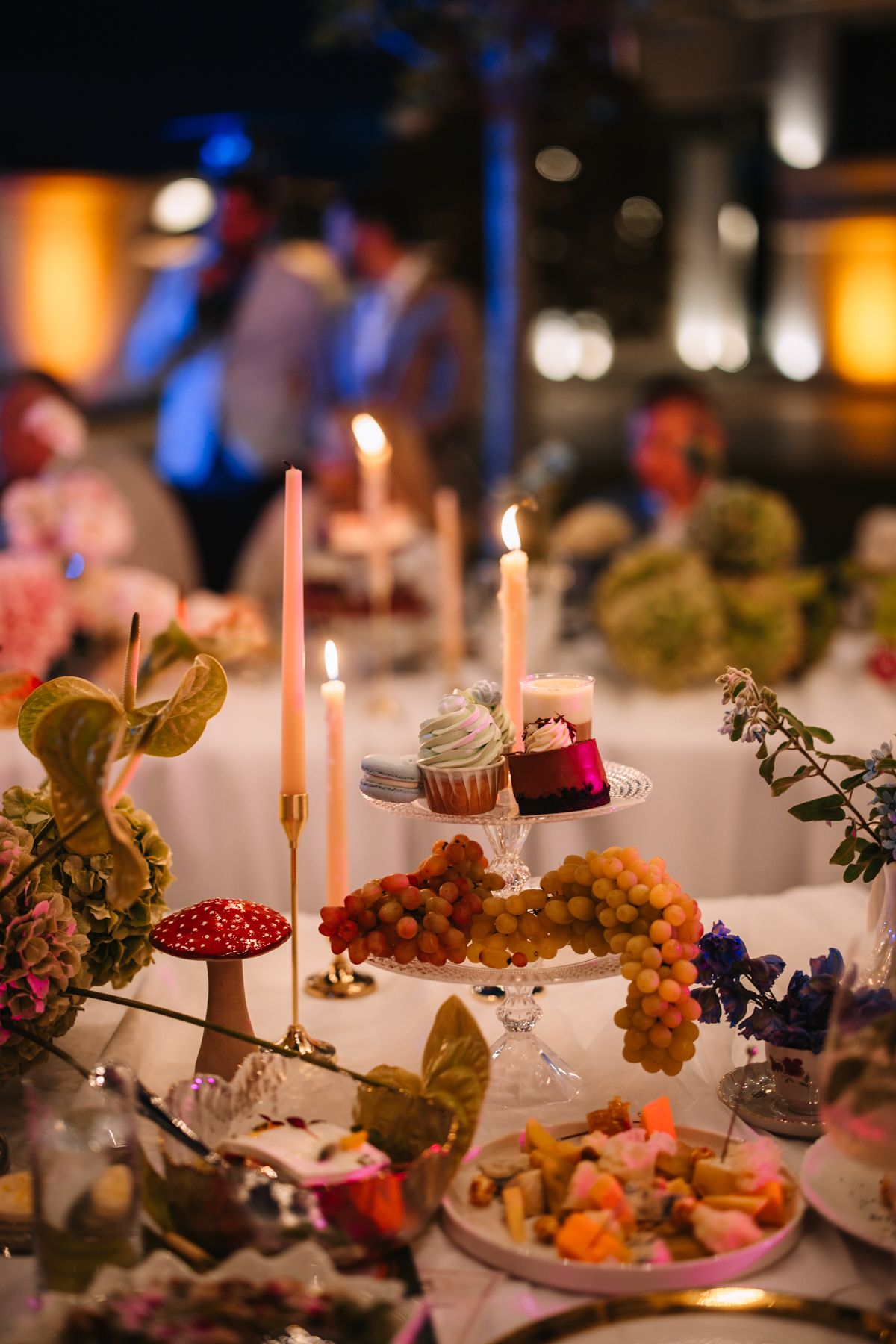 Elegant table settings with lit candles, autumn decorations, and desserts create a cozy dining atmosphere.