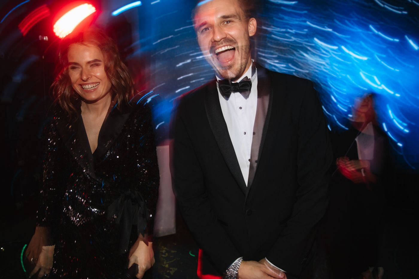 Formal event with dramatic blue and red lighting effects creating atmosphere.