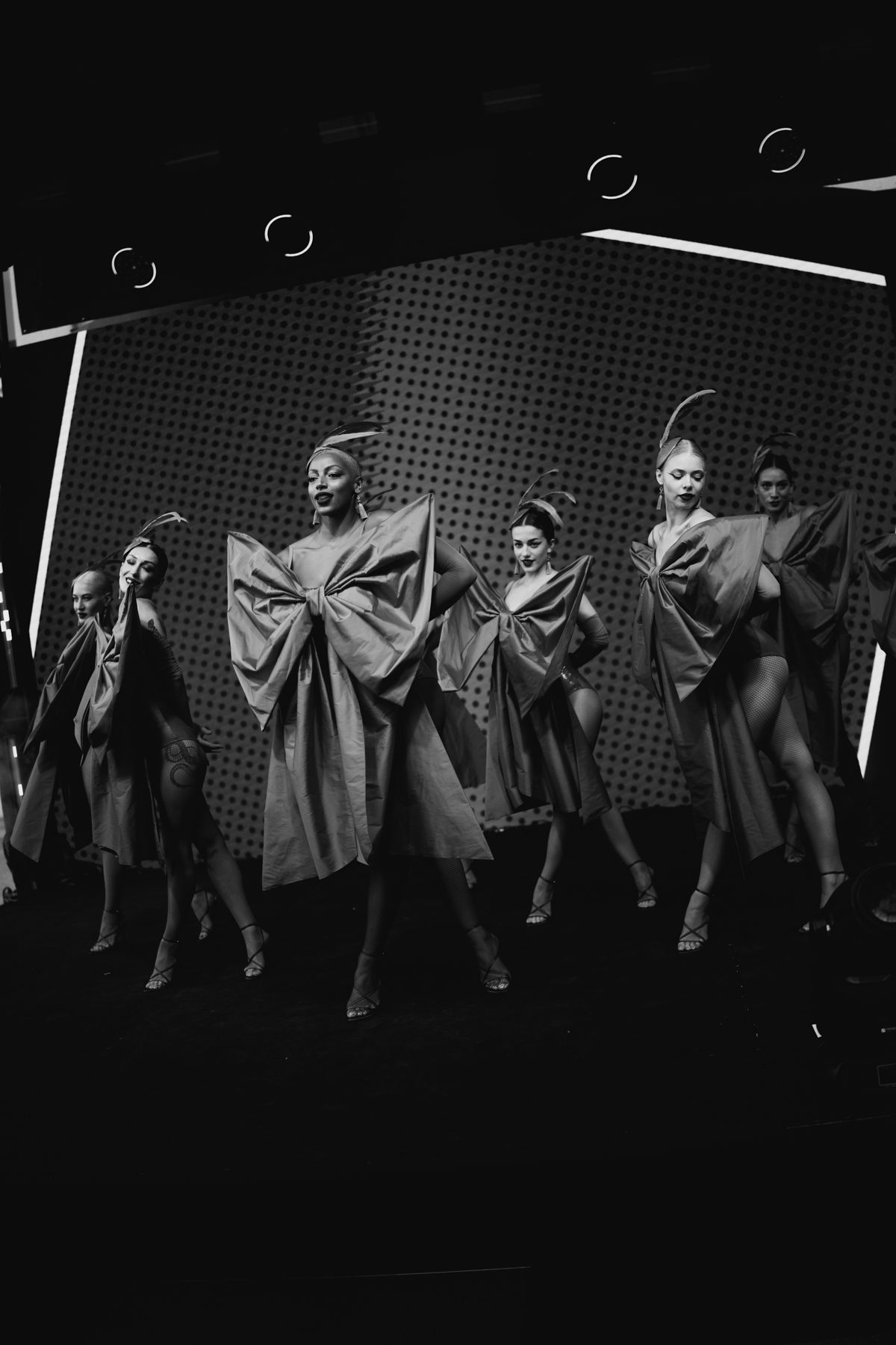 A black and white performance sequence shows dancers in flowing robes creating dramatic movements against a dark background.