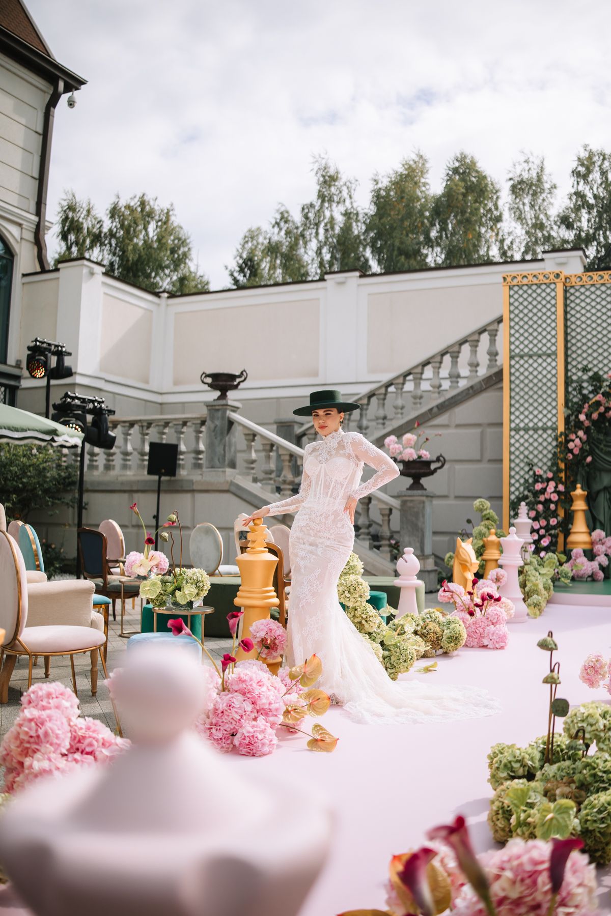 Elegant pink and white wedding reception decor with floral arrangements and ornate details at an outdoor venue.