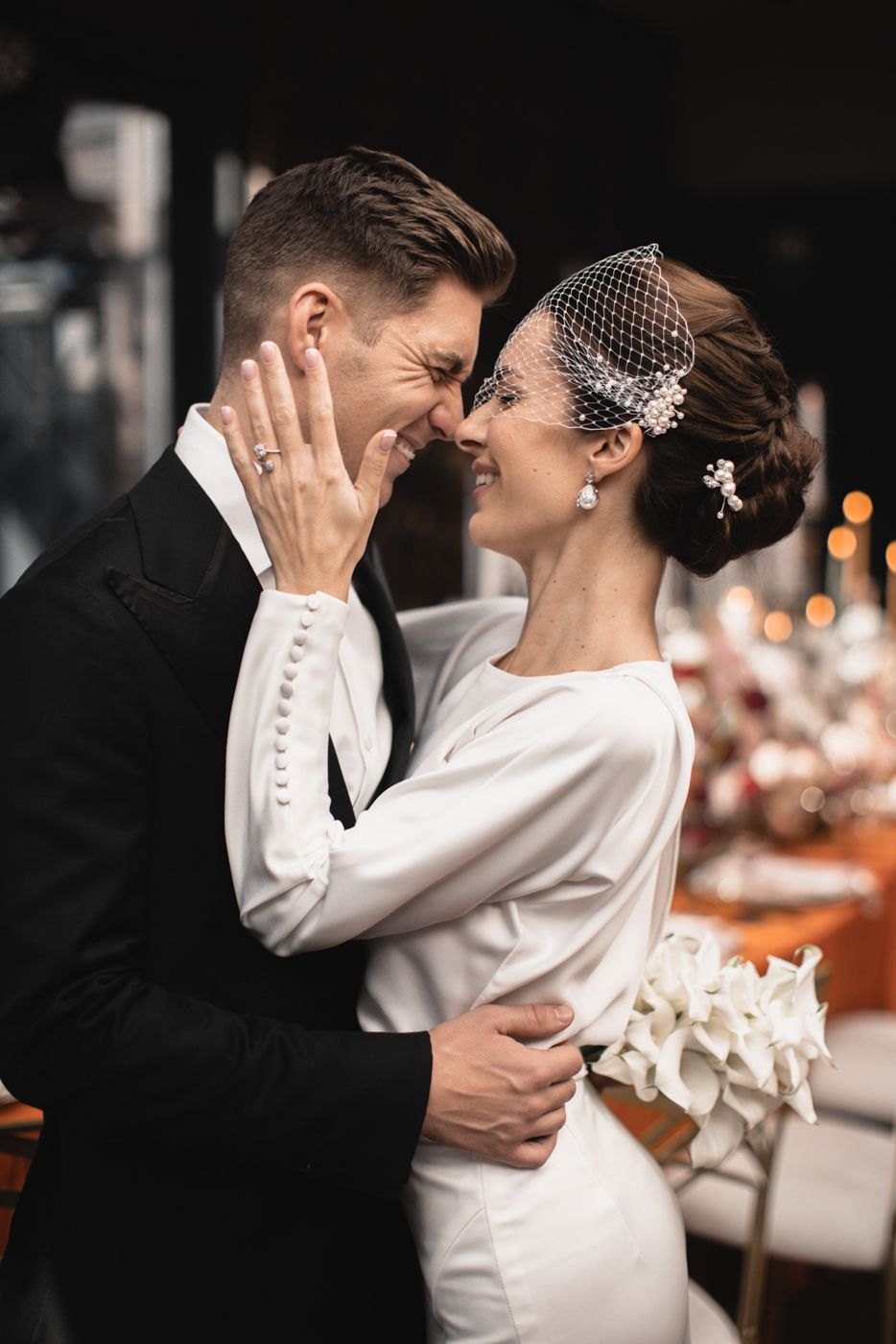 Intimate wedding moment captured in front of an elegant reception setting.