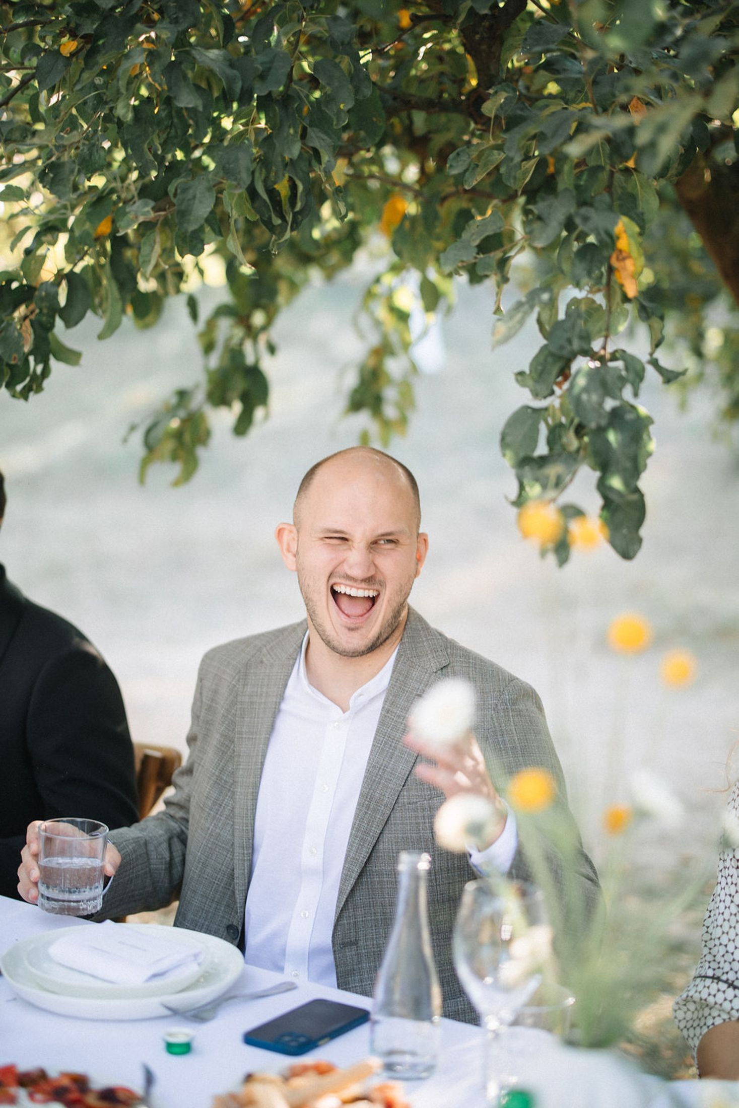 A joyful moment captured during an outdoor dining experience under a citrus tree.