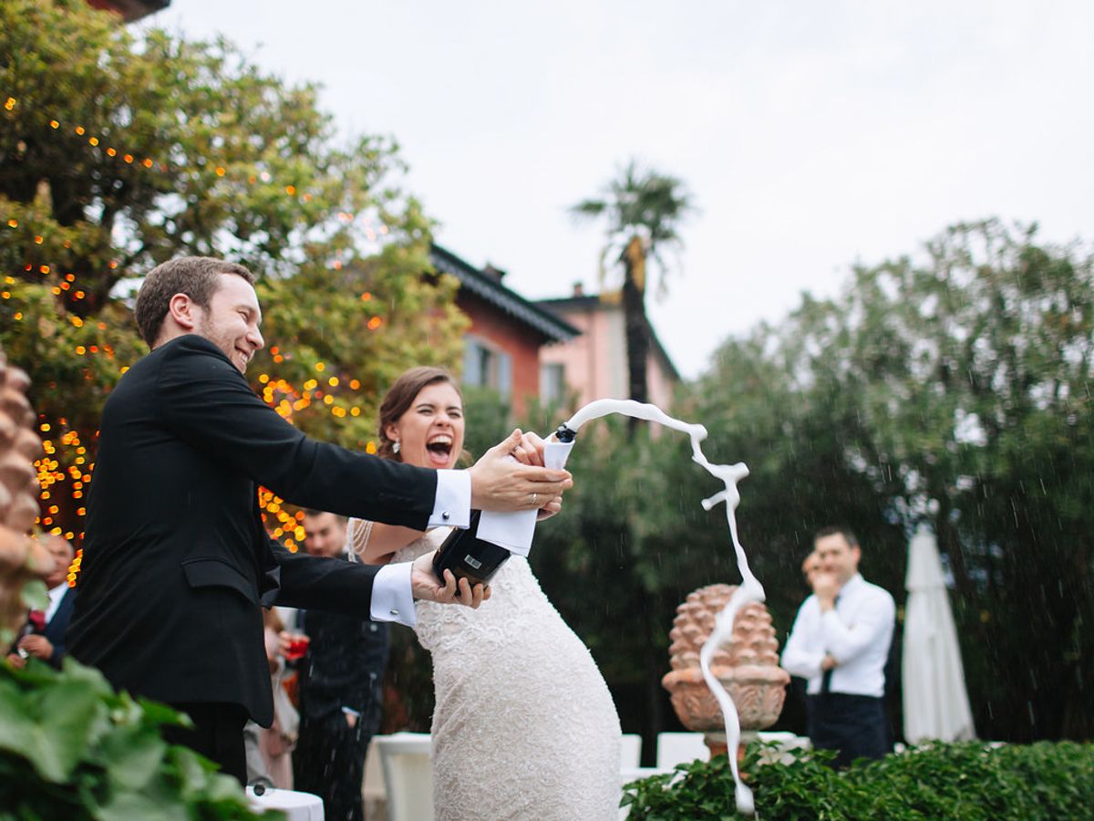 Newlyweds perform their first dance outdoors at a garden wedding reception with guests watching in the background.