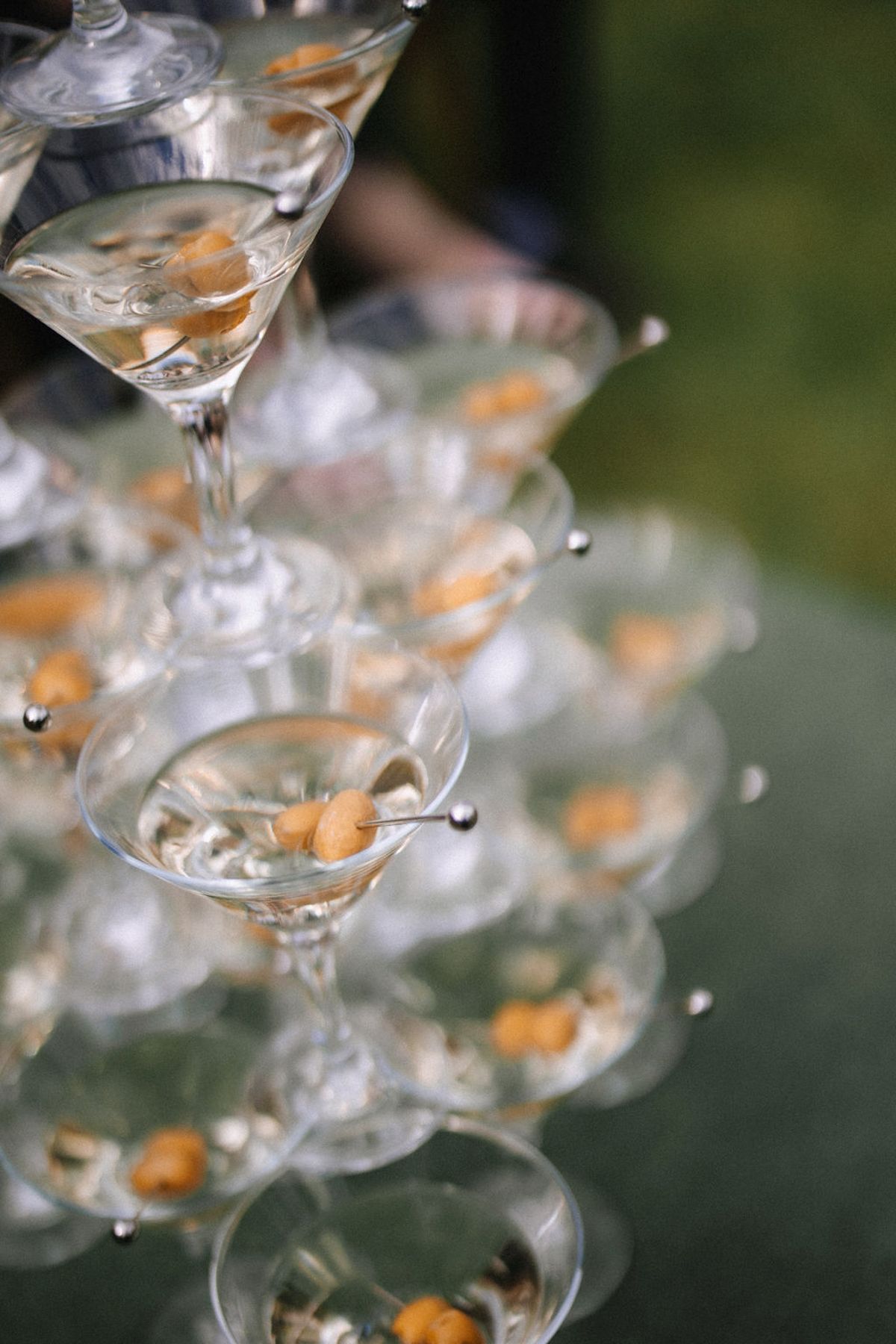 Multiple wine glasses arranged in a delicate pattern with orange reflections creating an ethereal bokeh effect.