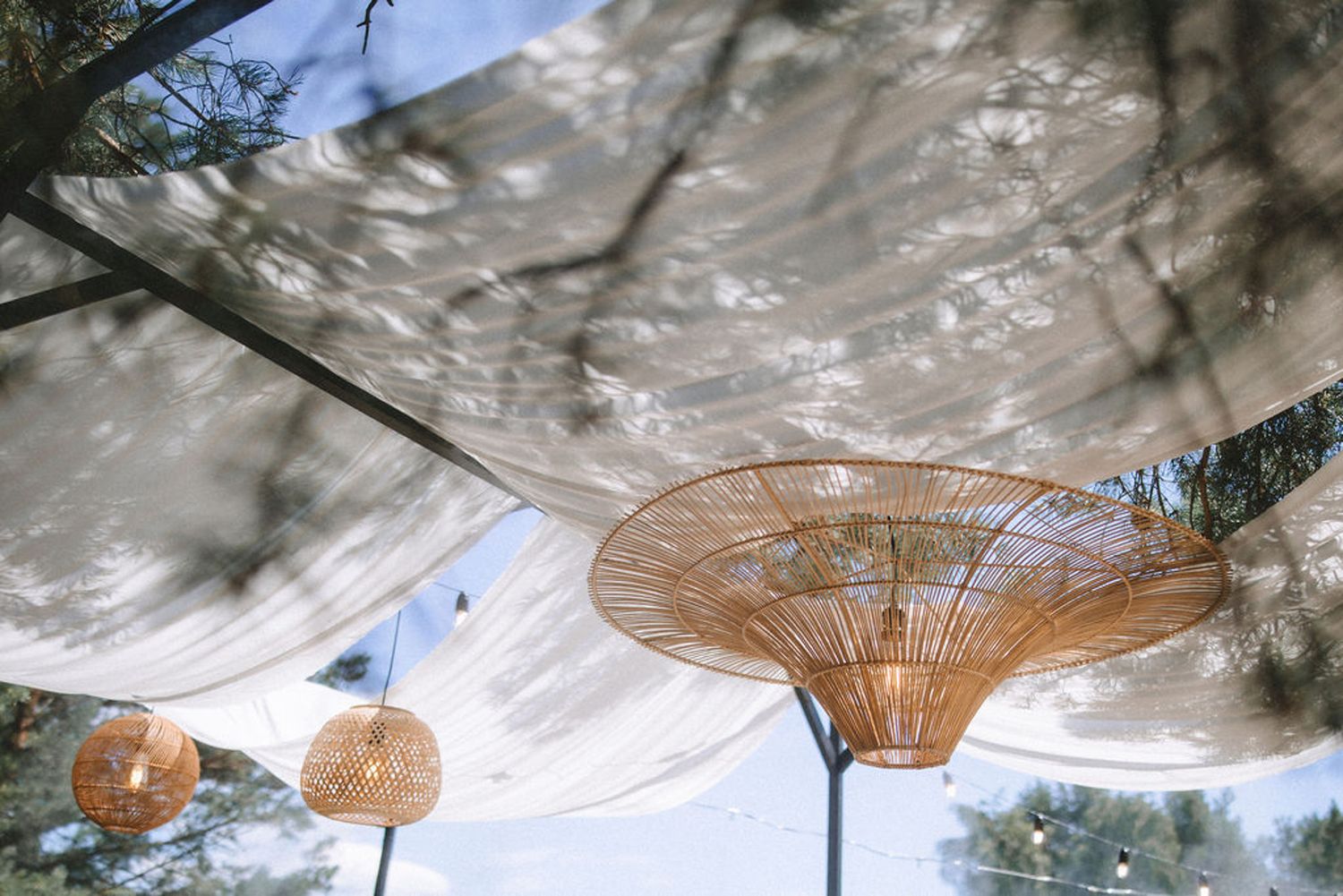 Multiple woven bamboo parasols or umbrellas hang from a ceiling, creating a natural decorative display.
