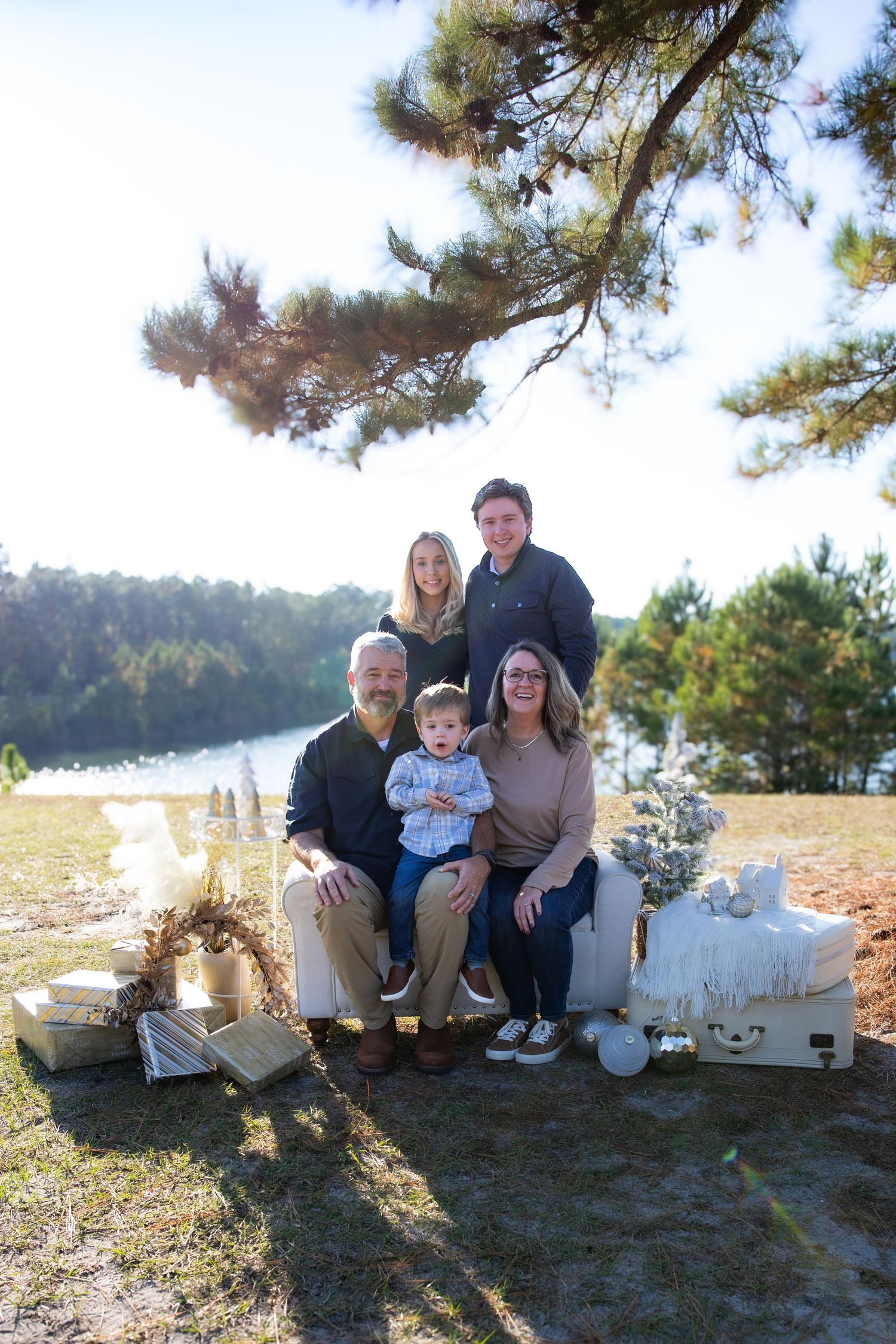 Family portrait session with autumn decor and a lake backdrop.