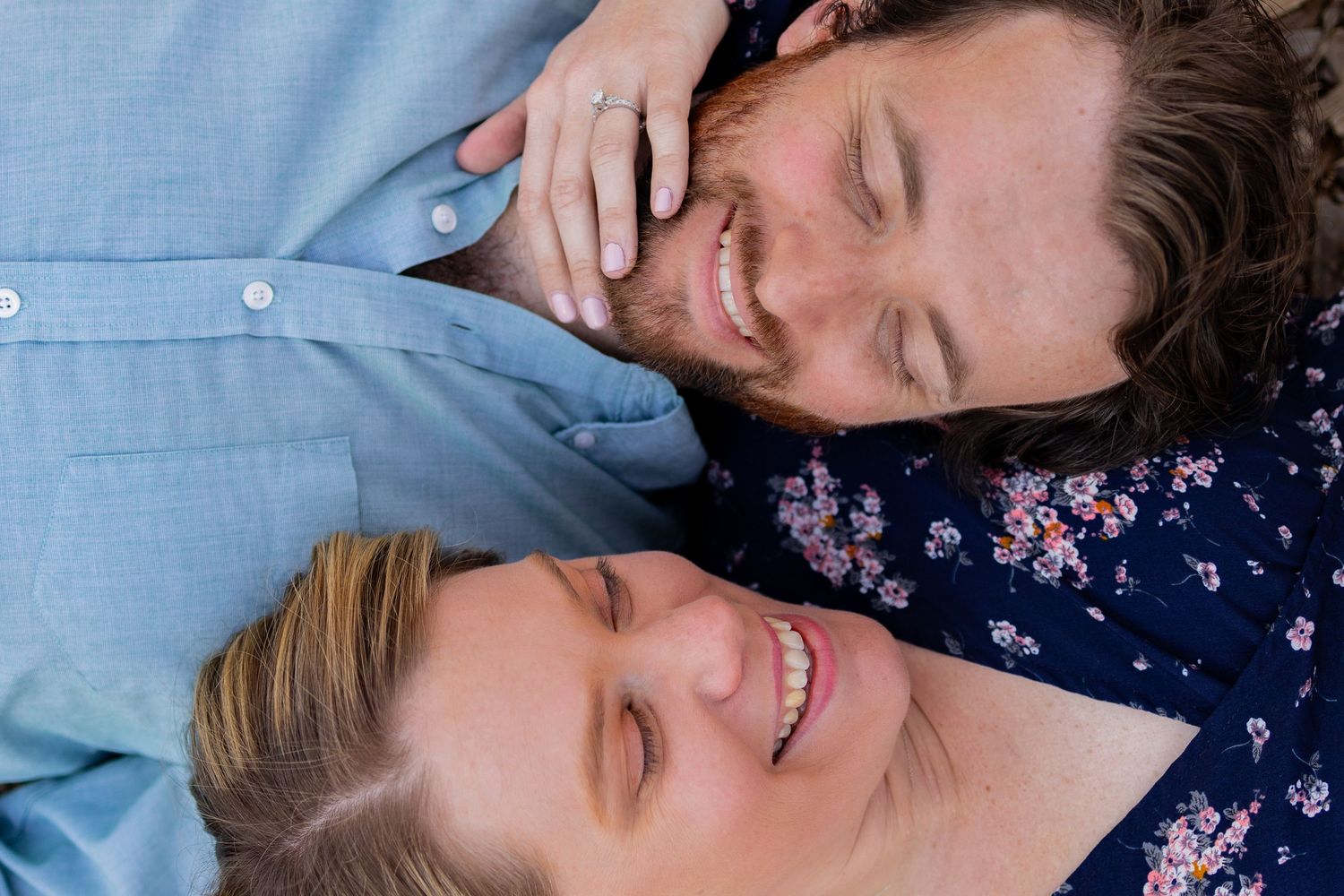 A playful couple shares tender moments while lying down together.
