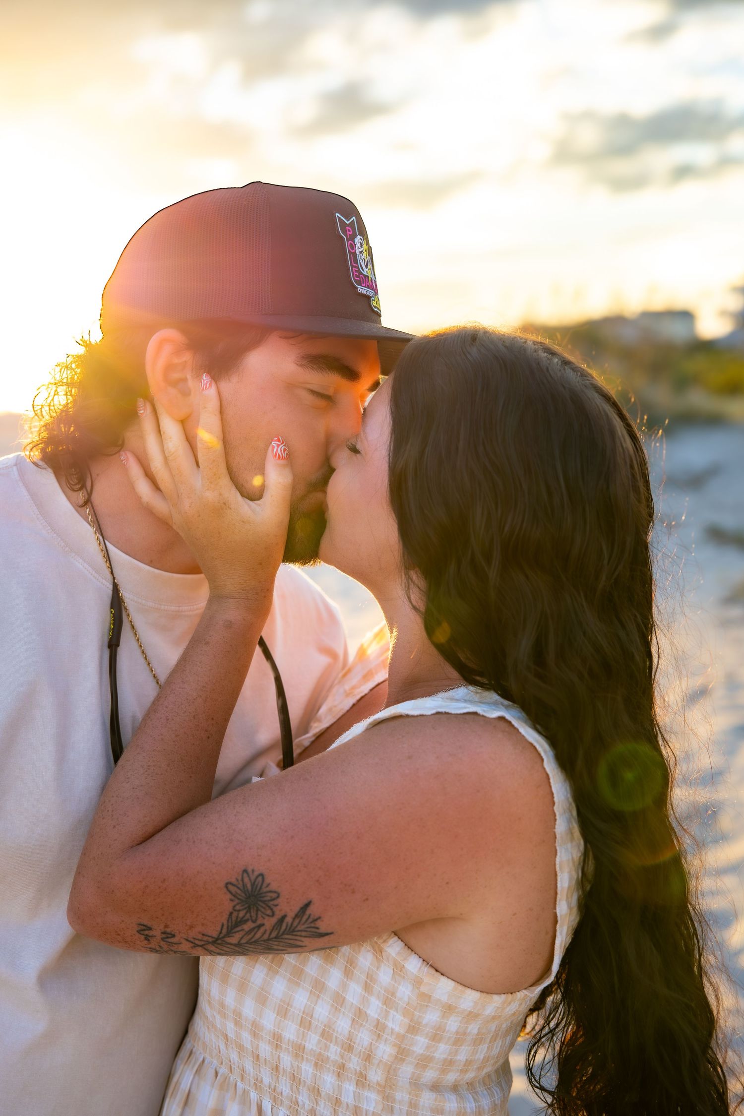 Intimate sunset beach portrait of a couple sharing a tender moment in golden light.