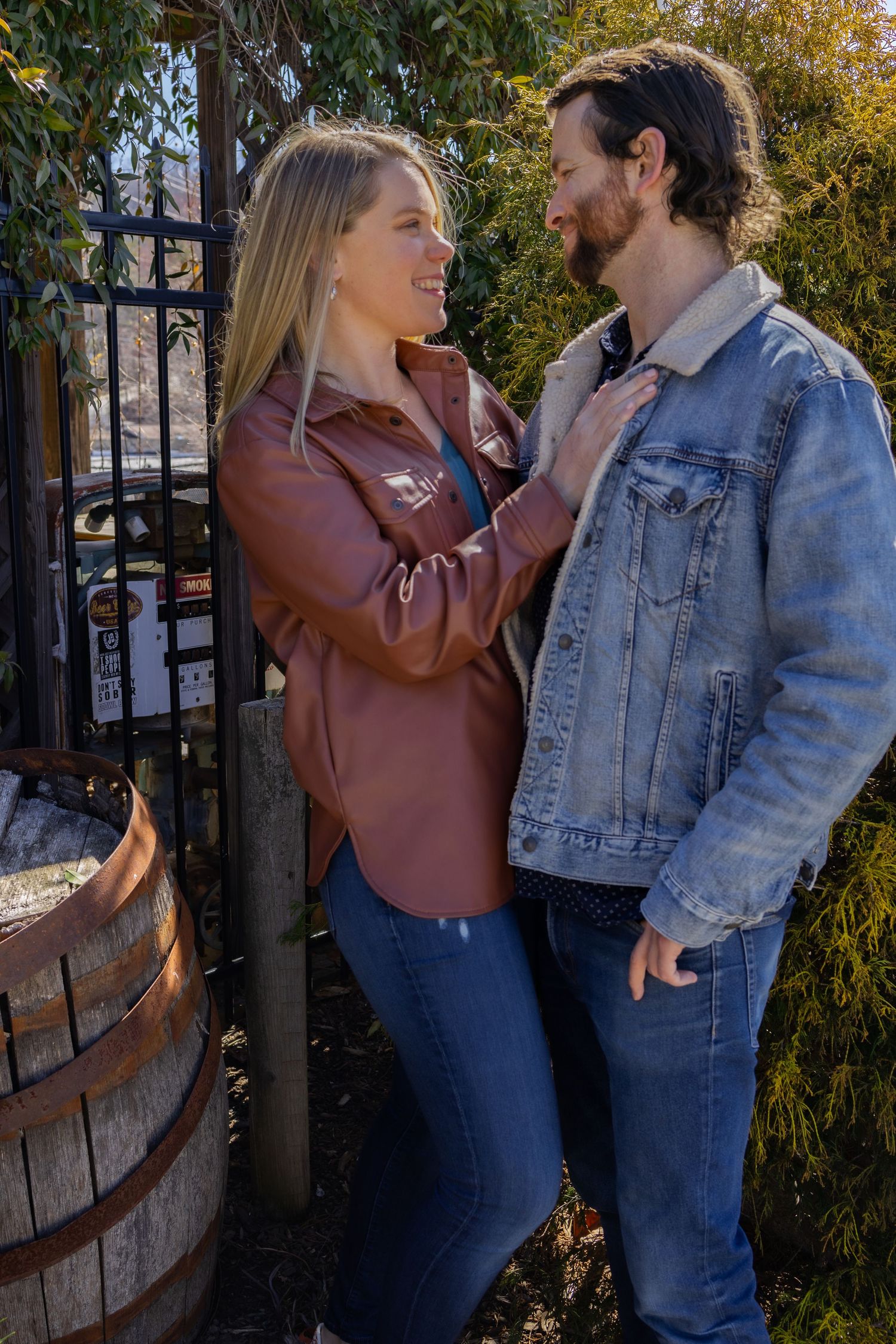 A couple shares romantic moments by an iron gate in autumn.