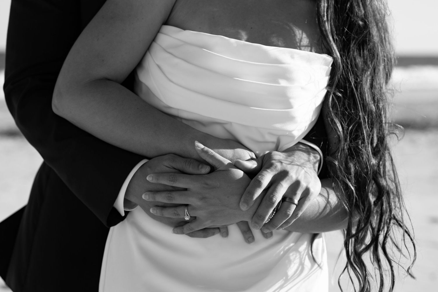 Black and white intimate portrait of couple embracing in formal wear.