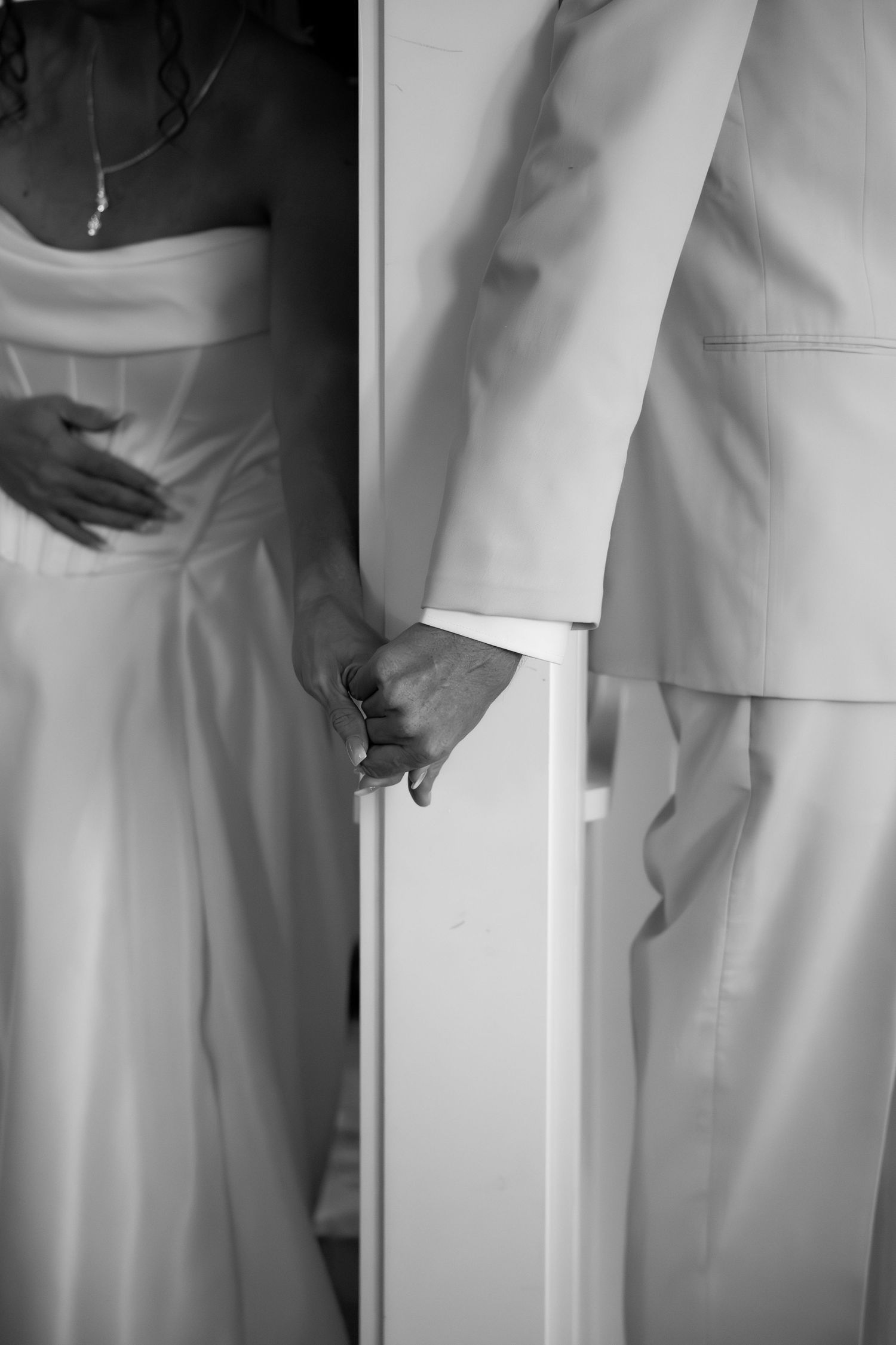 Black and white artistic shots showing elegant wedding attire details.