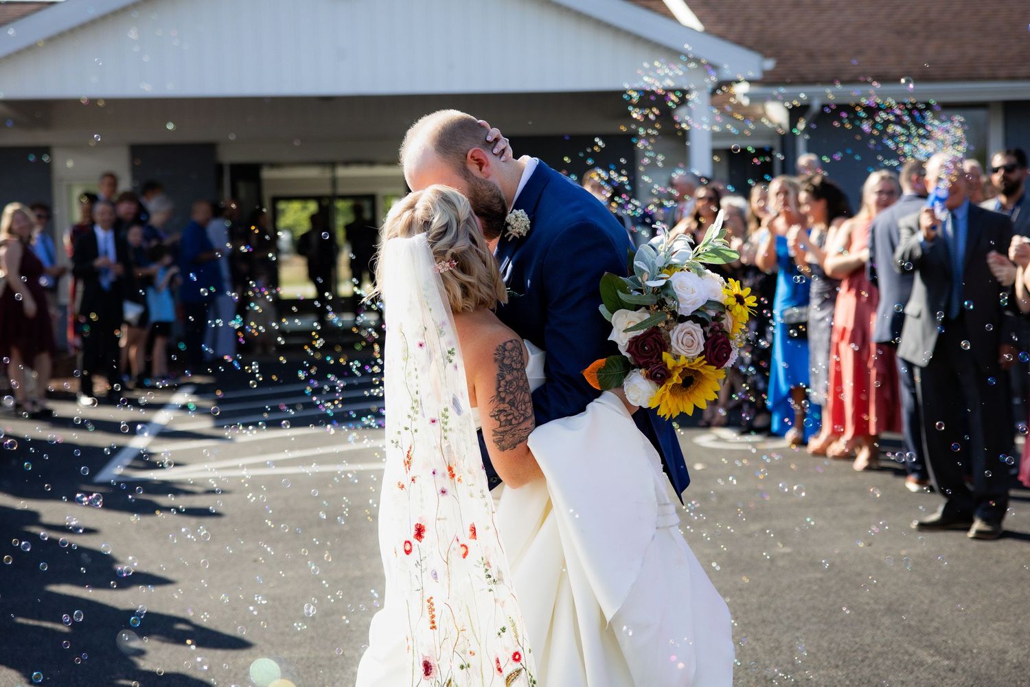 Wedding celebration with guests throwing confetti outside a building.