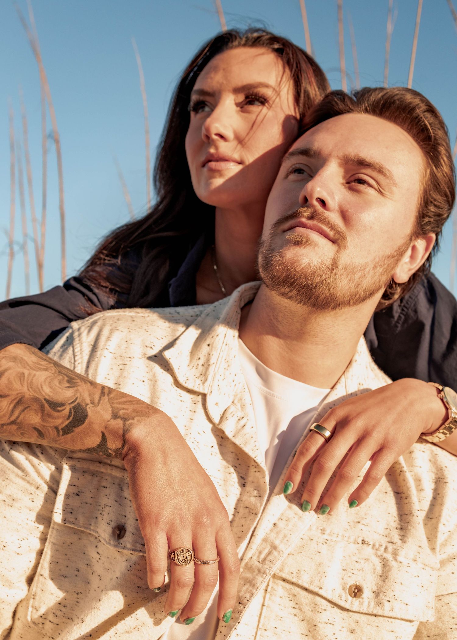 Intimate beach portrait showing couple in casual white and dark attire.