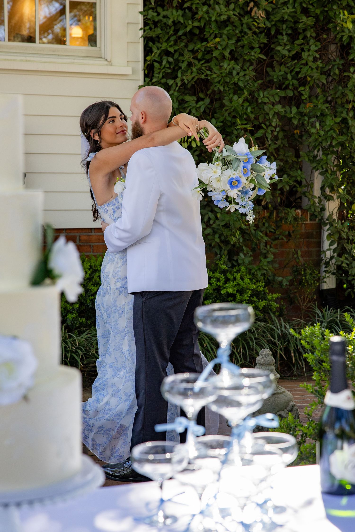 Wedding reception scene with elegant table settings and dancing in the background.