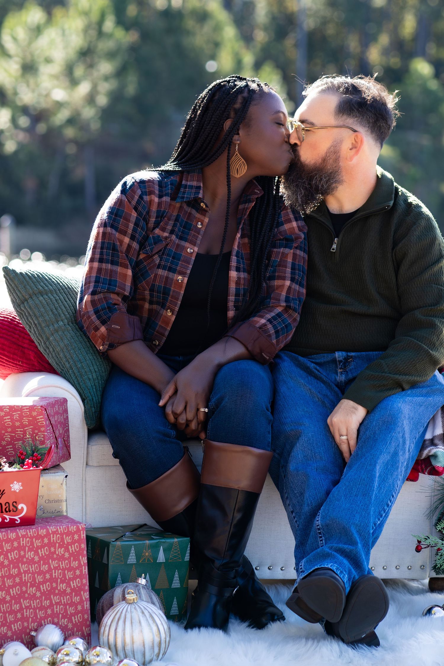 Cozy winter photoshoot with couple sitting among holiday decorations and lanterns.