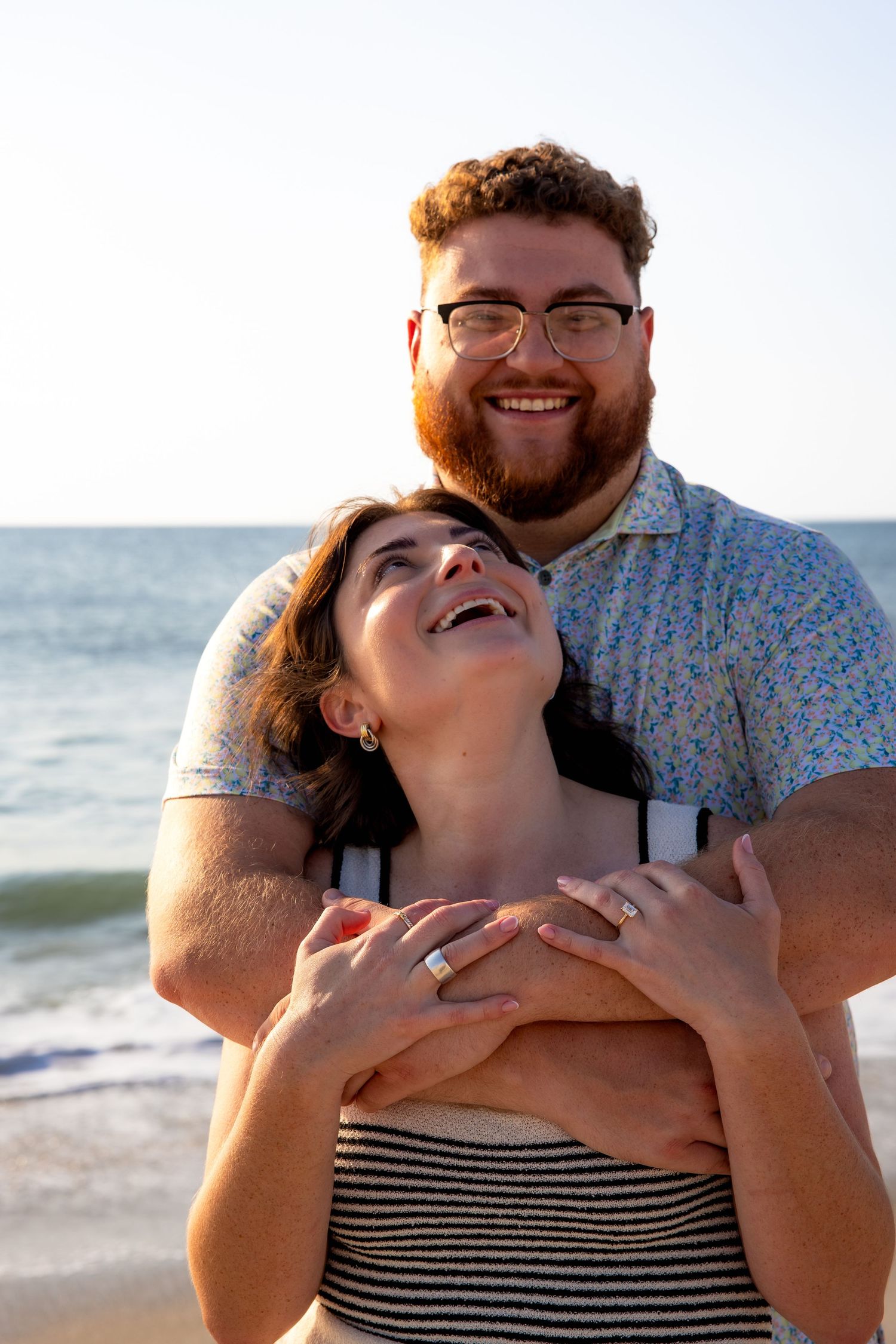 Happy couple sharing joyful moment together at beach during sunset.