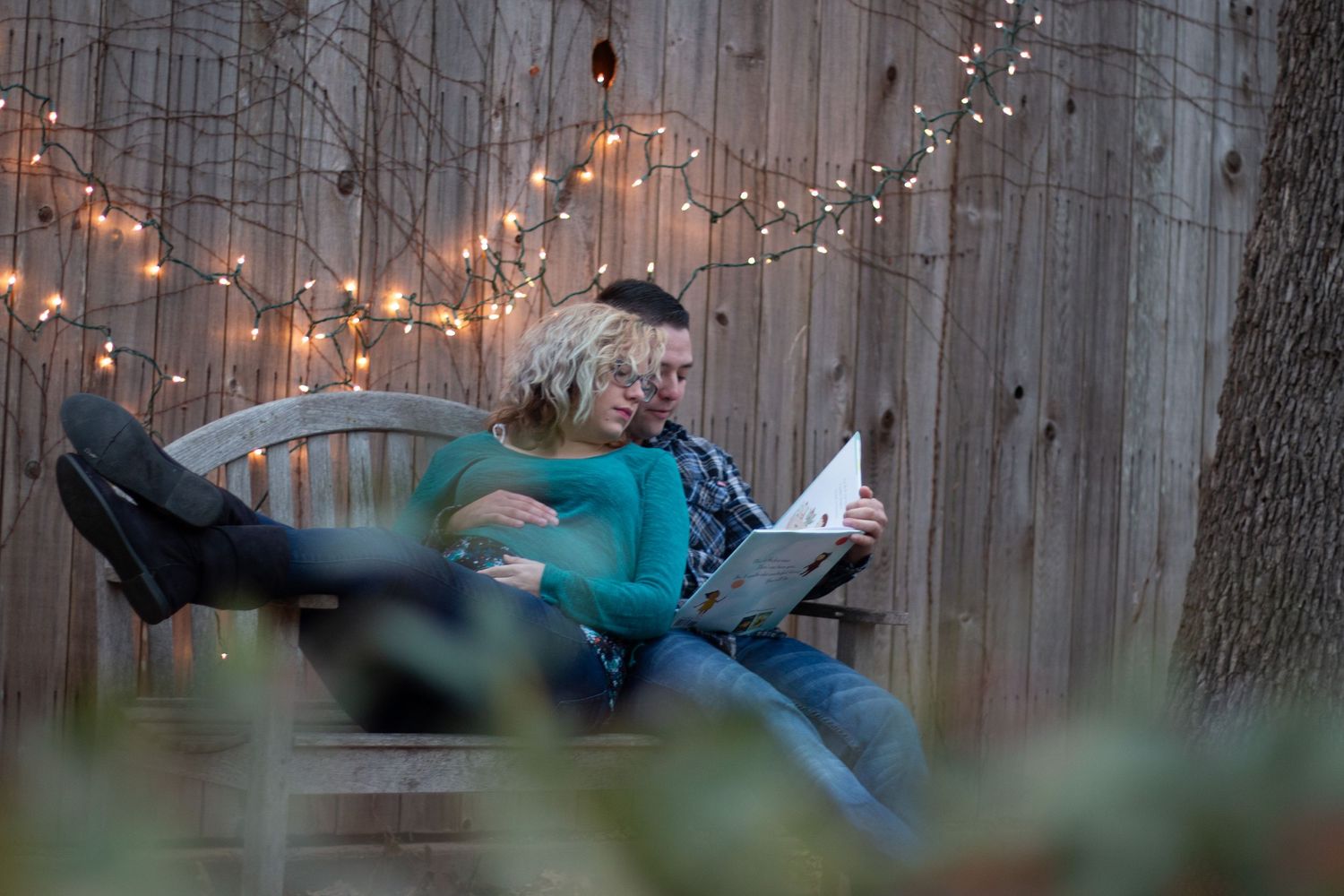 String lights illuminate rustic wooden fence at dusk creating romantic ambiance.