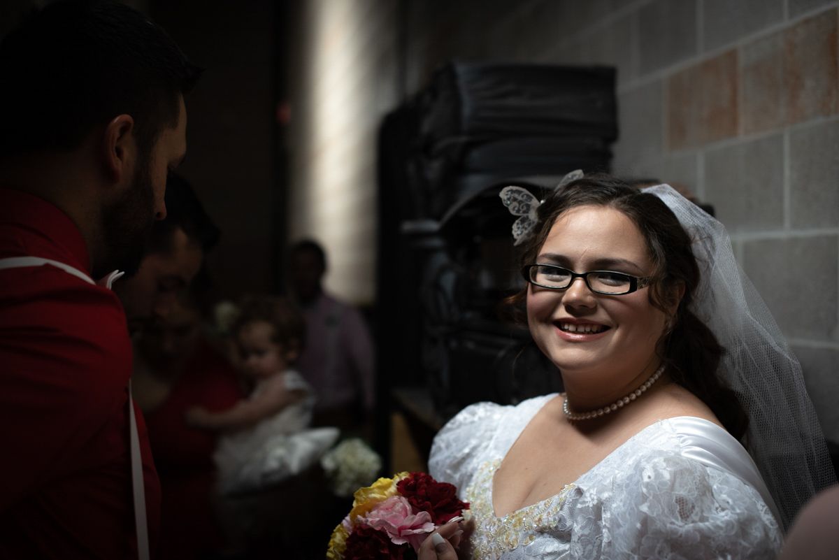 Elegant wedding celebration scene with white decor and dramatic lighting.
