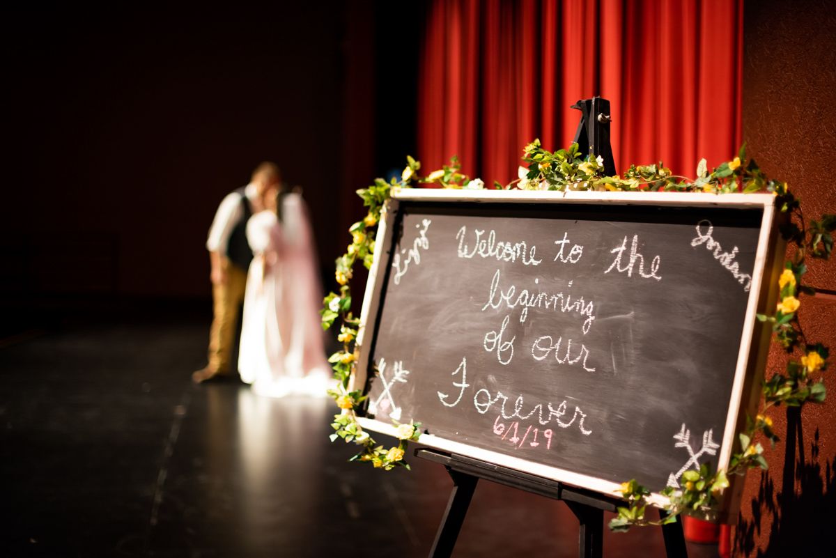 Decorative chalkboard signs with floral accents displayed at a wedding reception.