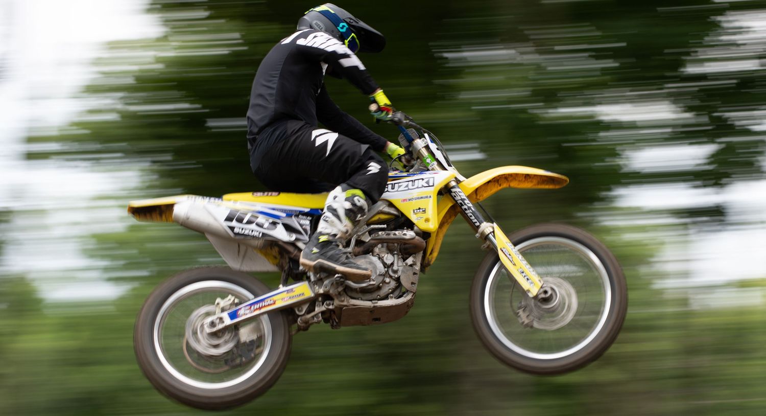Yellow motocross bike performing aerial jumps with motion blur effect.
