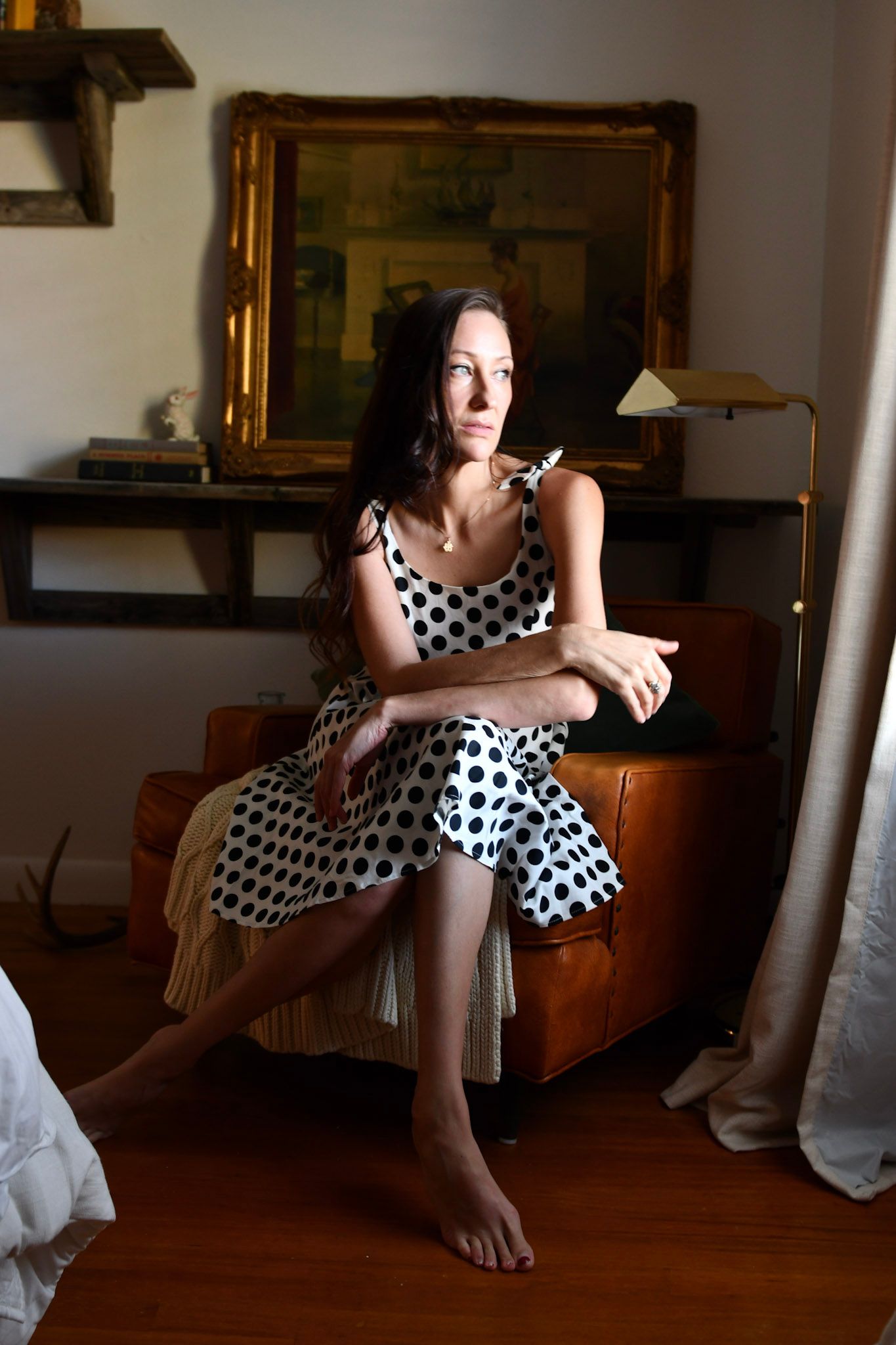 Indoor portrait session featuring polka dot dress in warm natural lighting on skin captured by Texas photographer