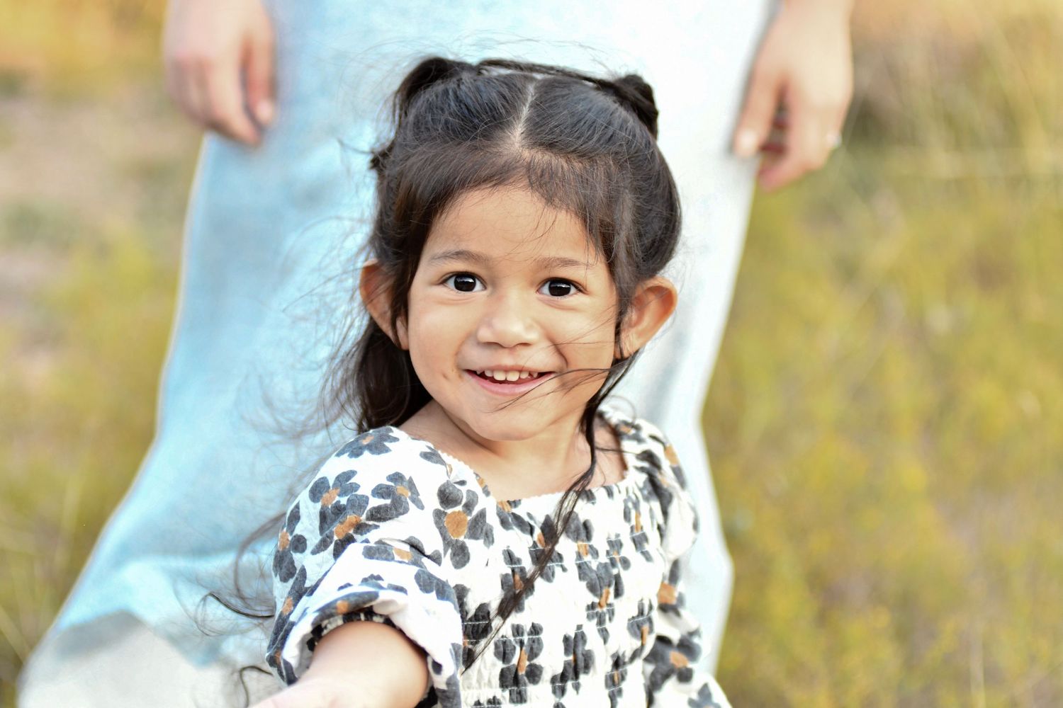 A series of candid outdoor family portraits with natural expressions.