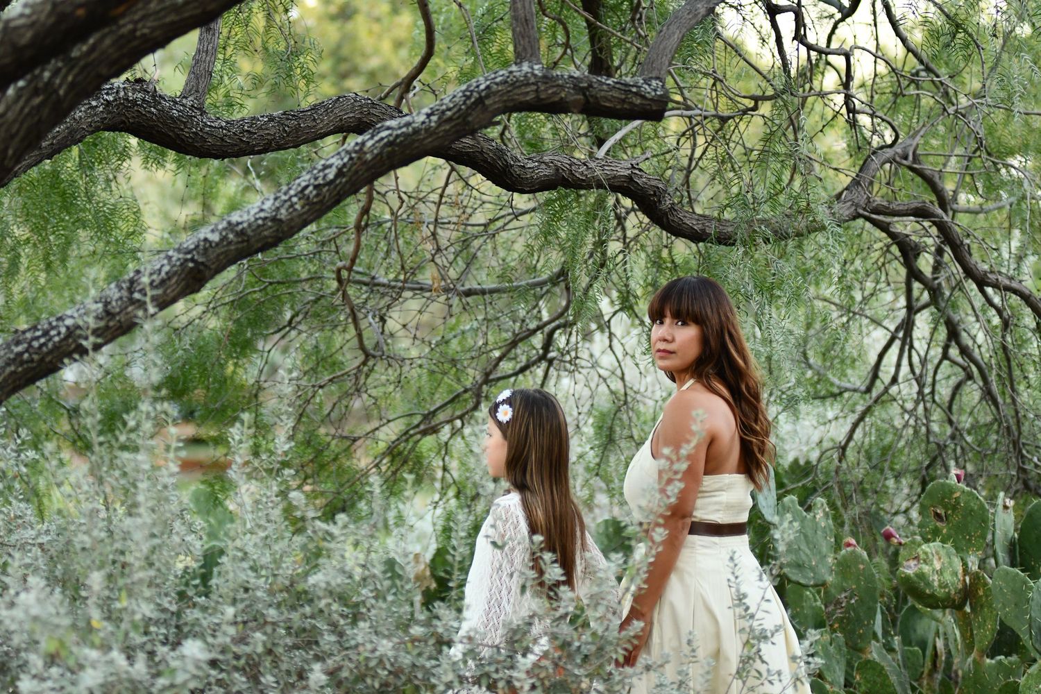 Texas photographer captures woman walking with child under large oak tree branches in nature.