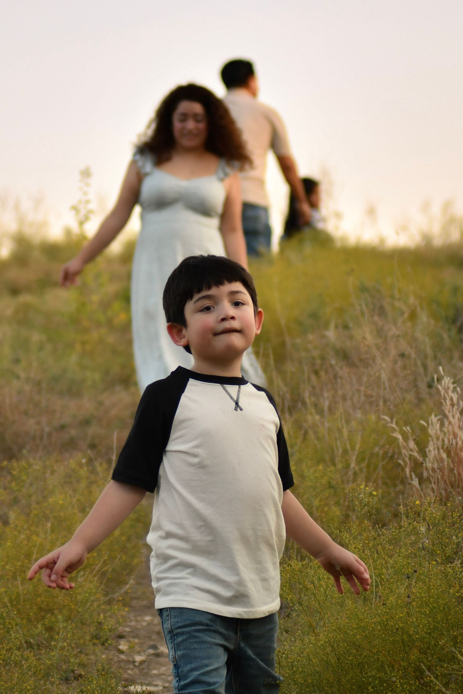 A child runs joyfully through a sunlit field during golden hour.