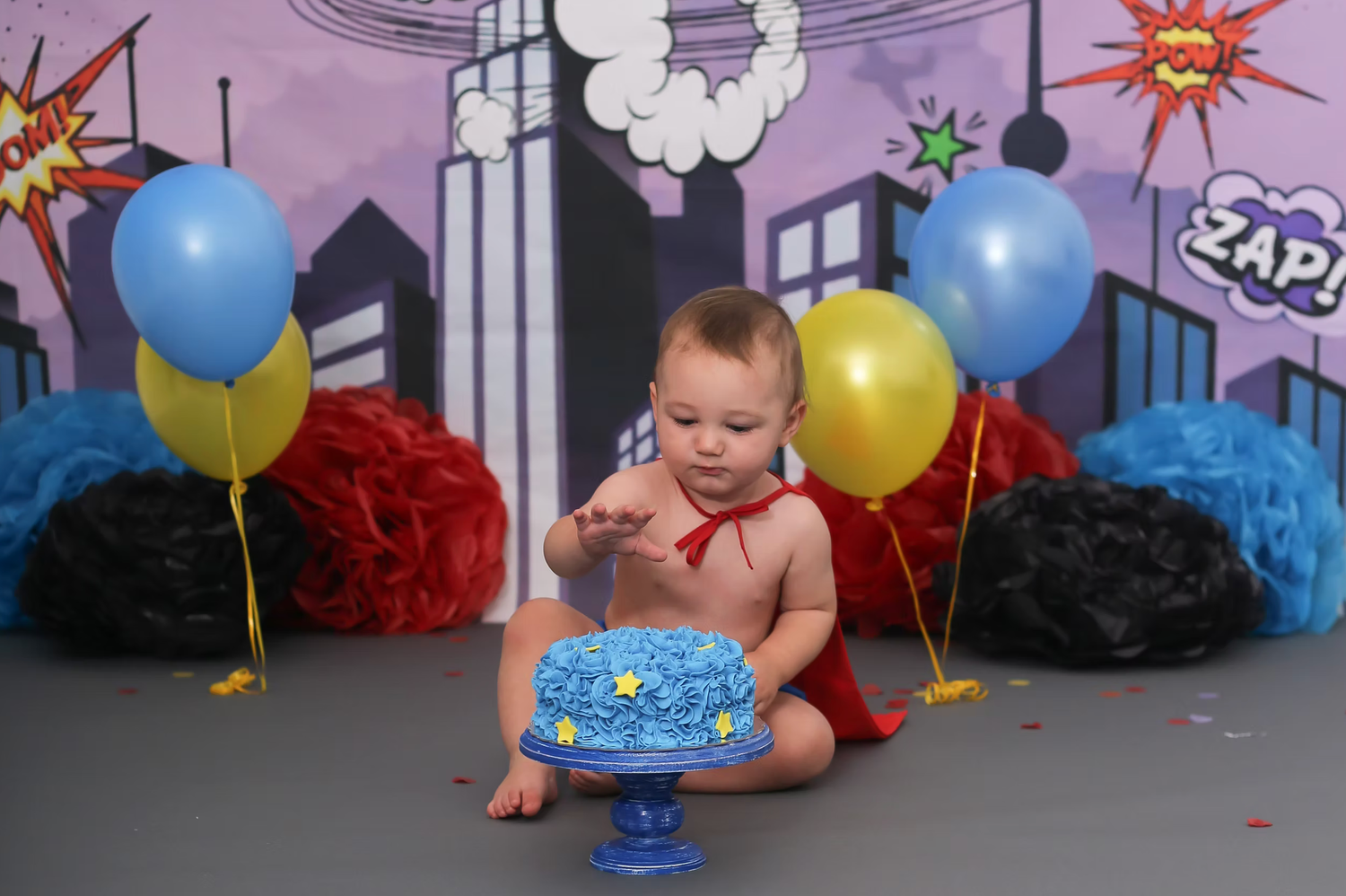 Superhero themed birthday setup with comic book style decorations and colorful balloons.