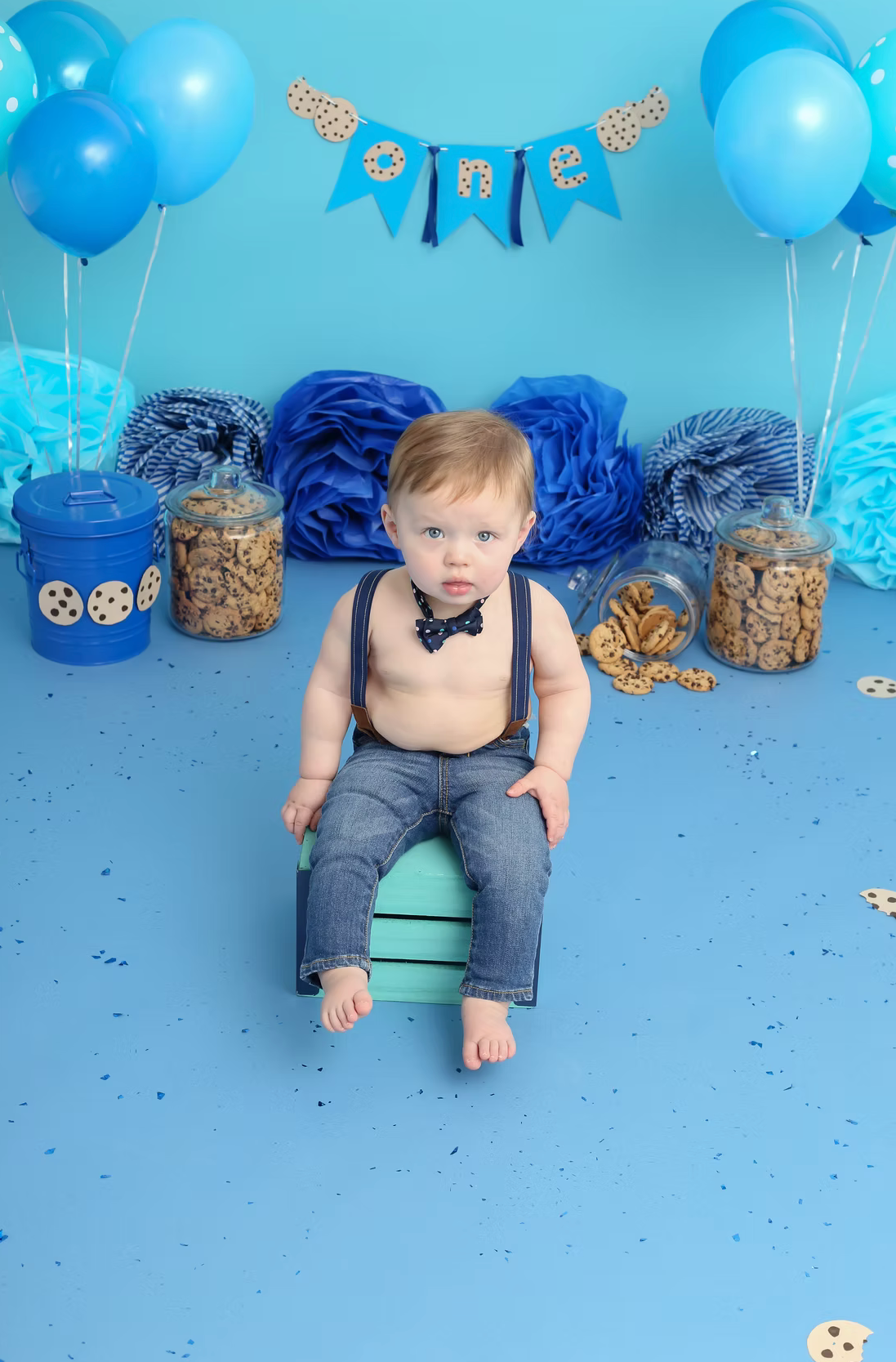 Cookie monster themed cake smash setup with blue balloons and decorations.