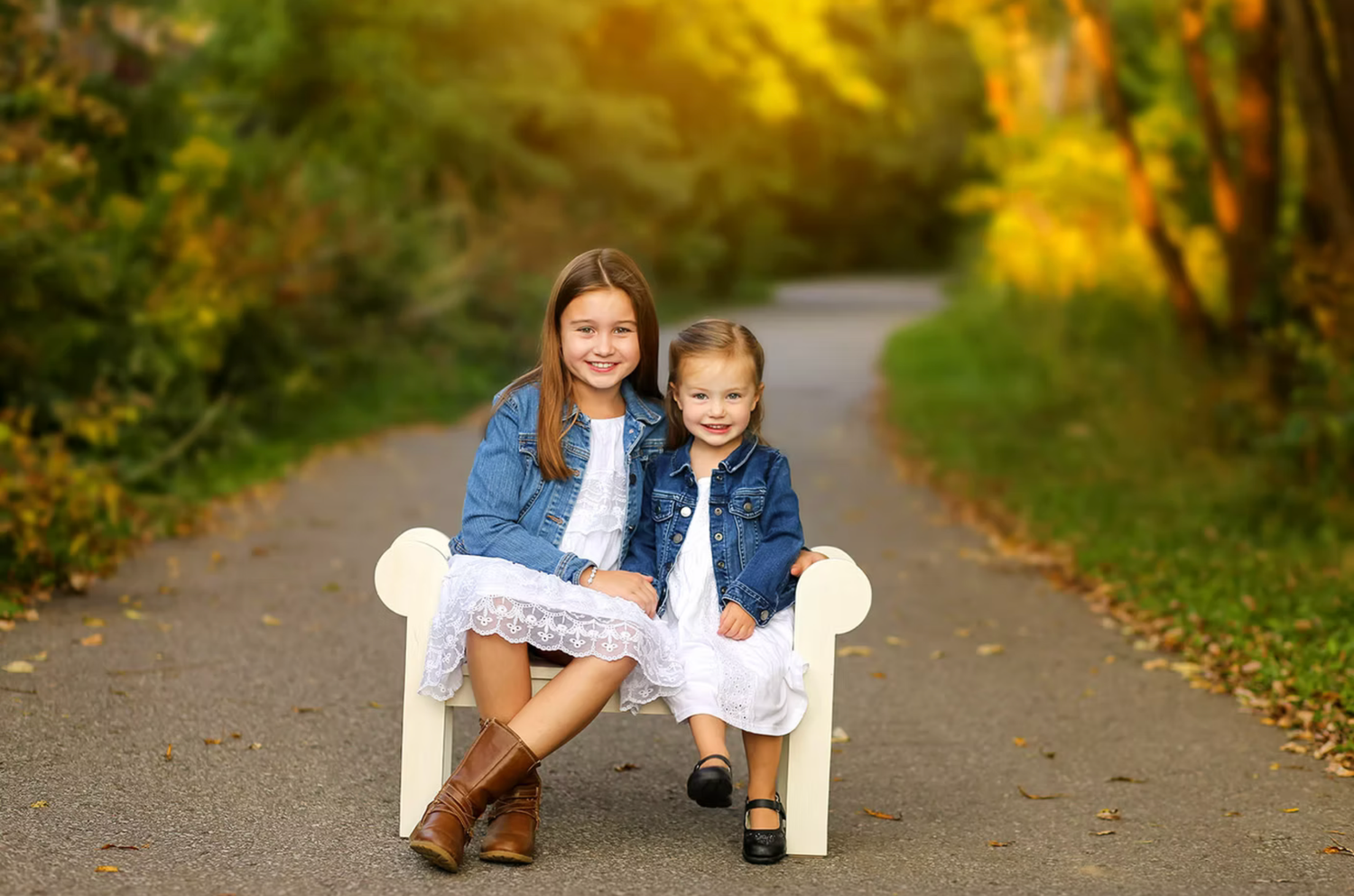 Family portraits on tree-lined path with golden autumn lighting.