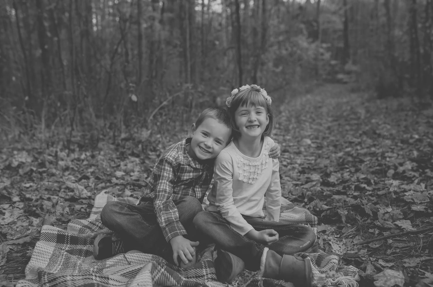 Black and white family photos taken in a wooded setting with fallen leaves.