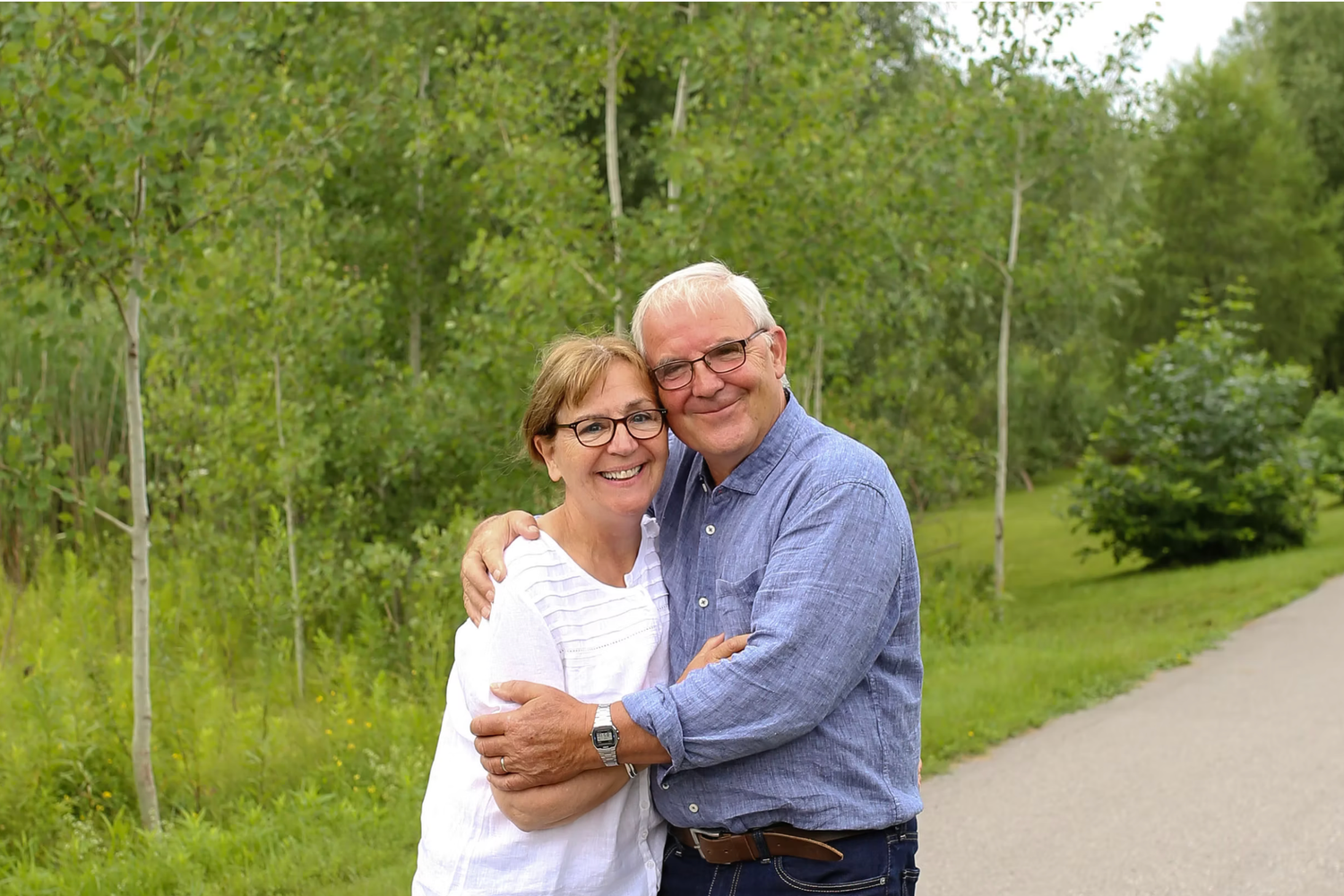 Candid outdoor family portraits taken on walking path surrounded by greenery.